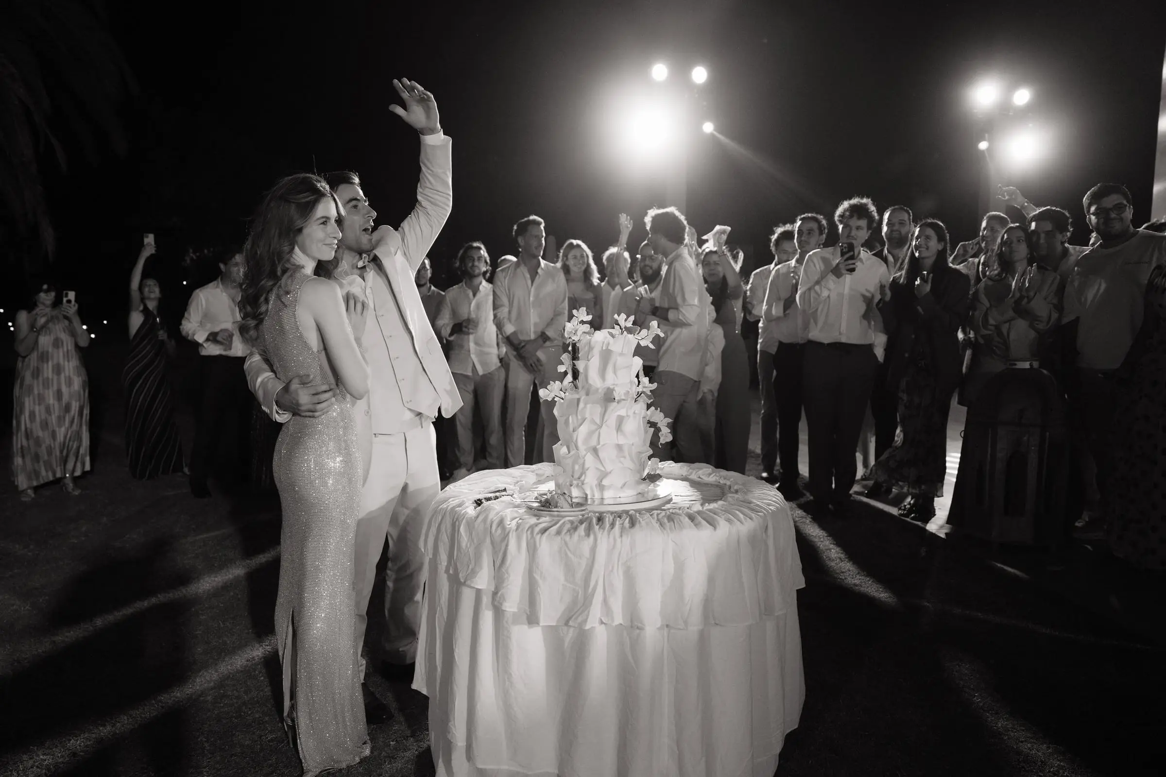 Black and white photo of the couple beside the wedding cake