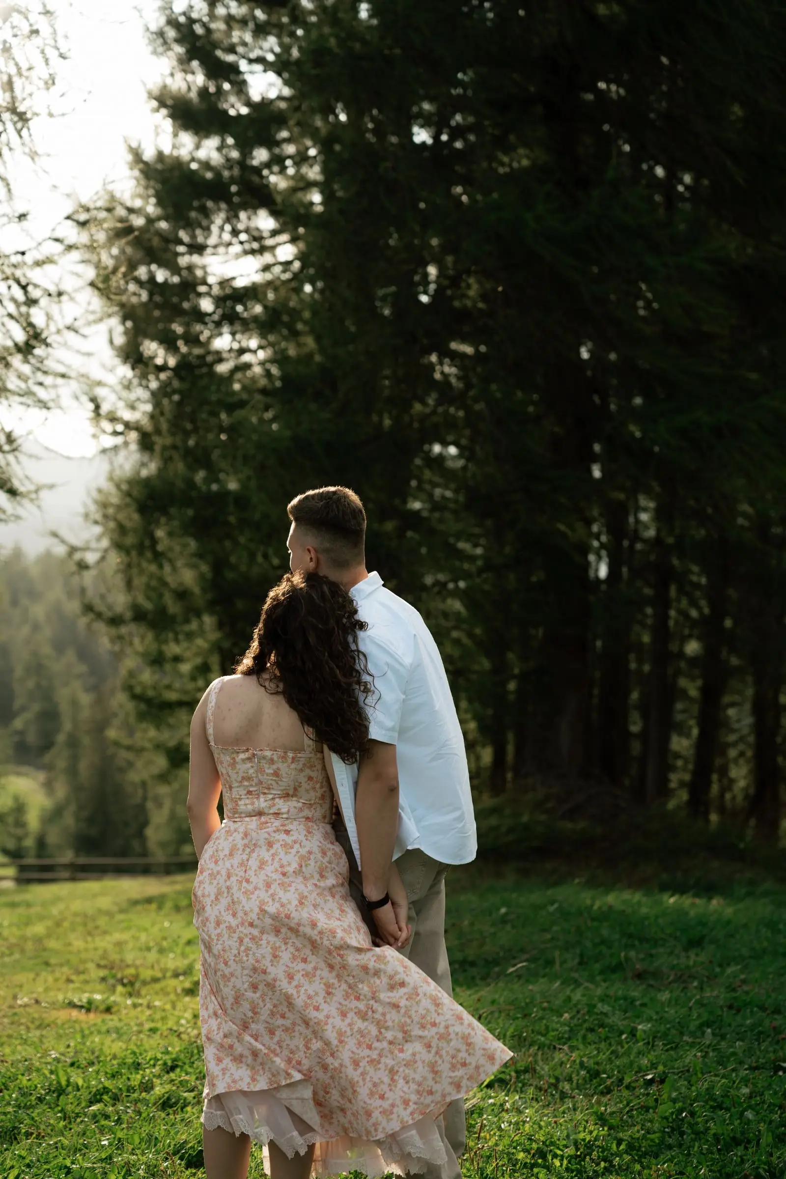 Couple walking together at the edge of a larch forest