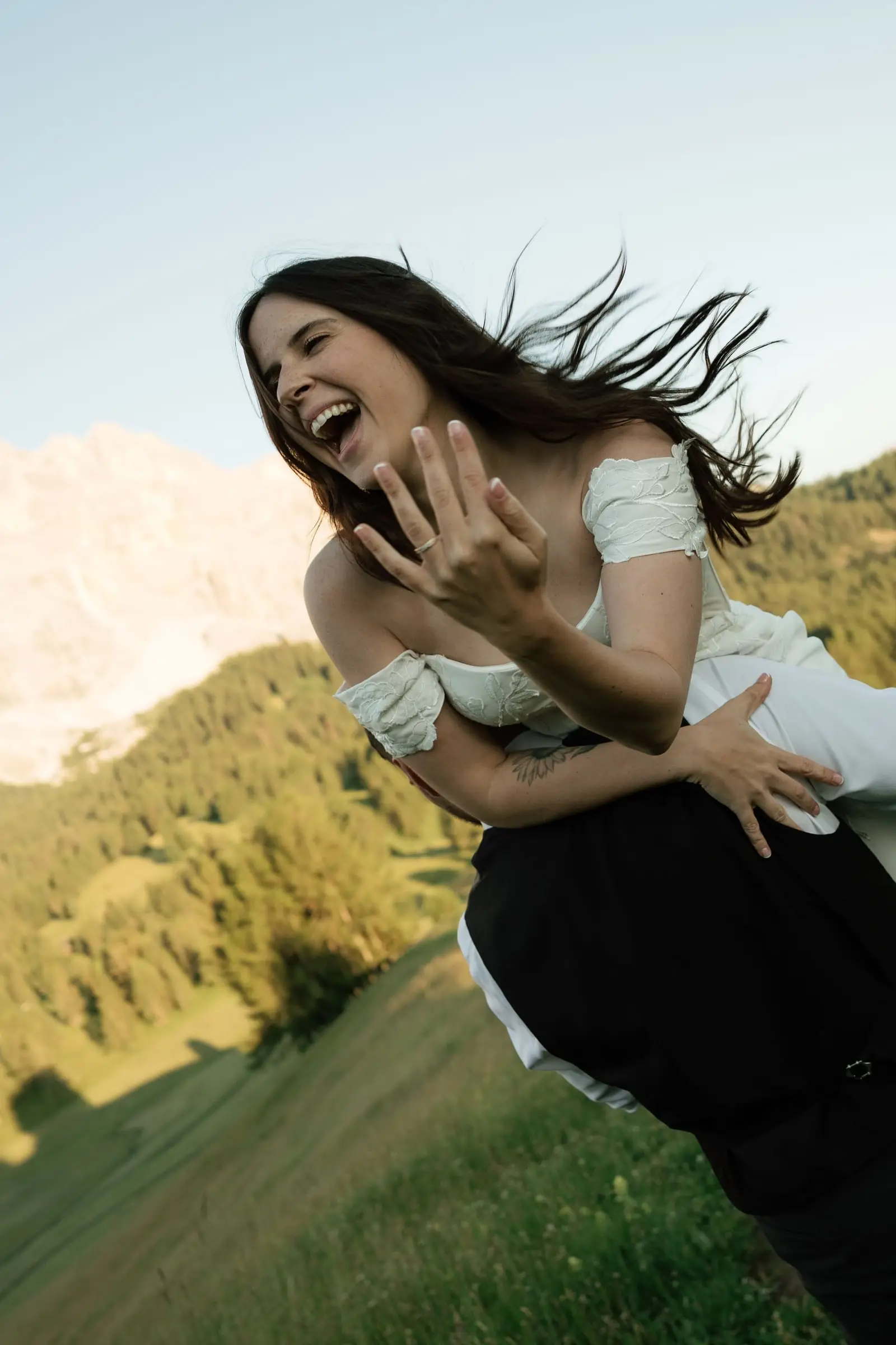 Laughing bride shows her ring while the groom dips her