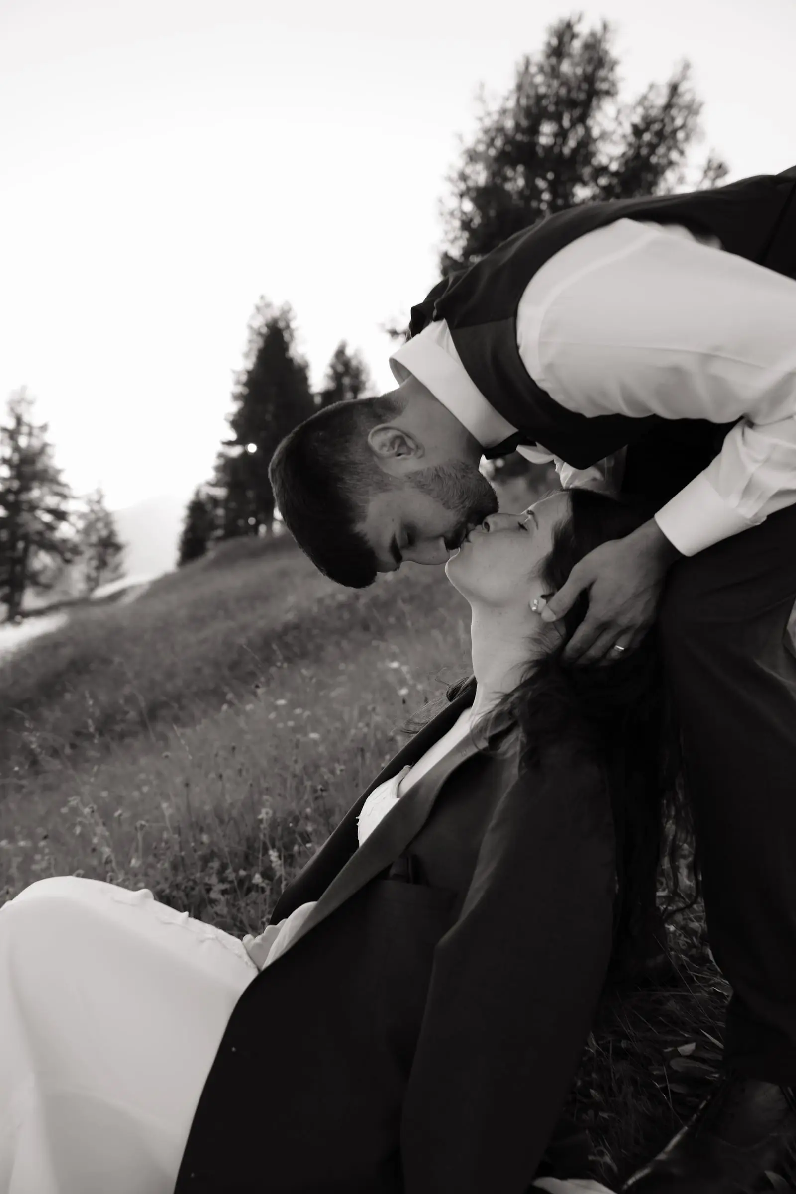 Black and white photo of the groom dipping and kissing the bride