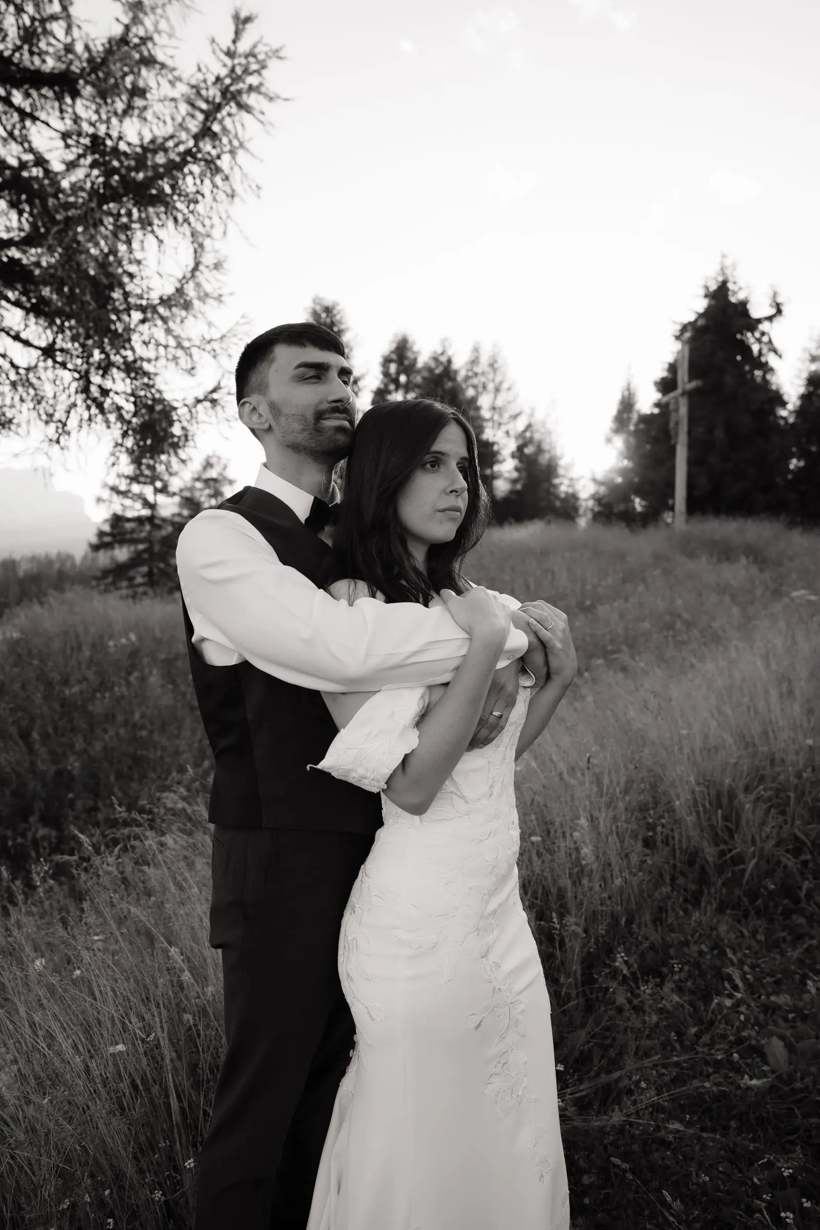 Black and white photo of the groom holding the bride from behind