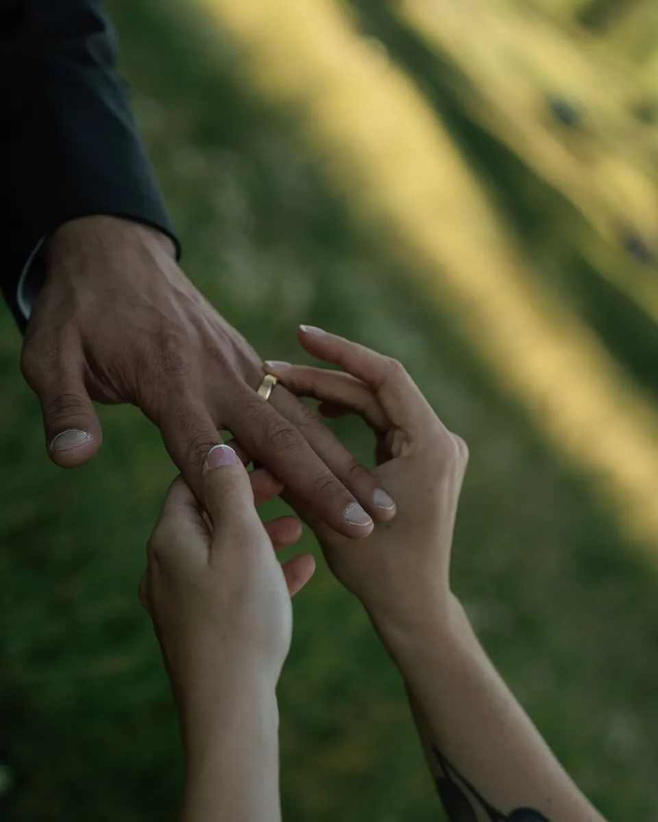 Bride puts the wedding ring on the groom's finger