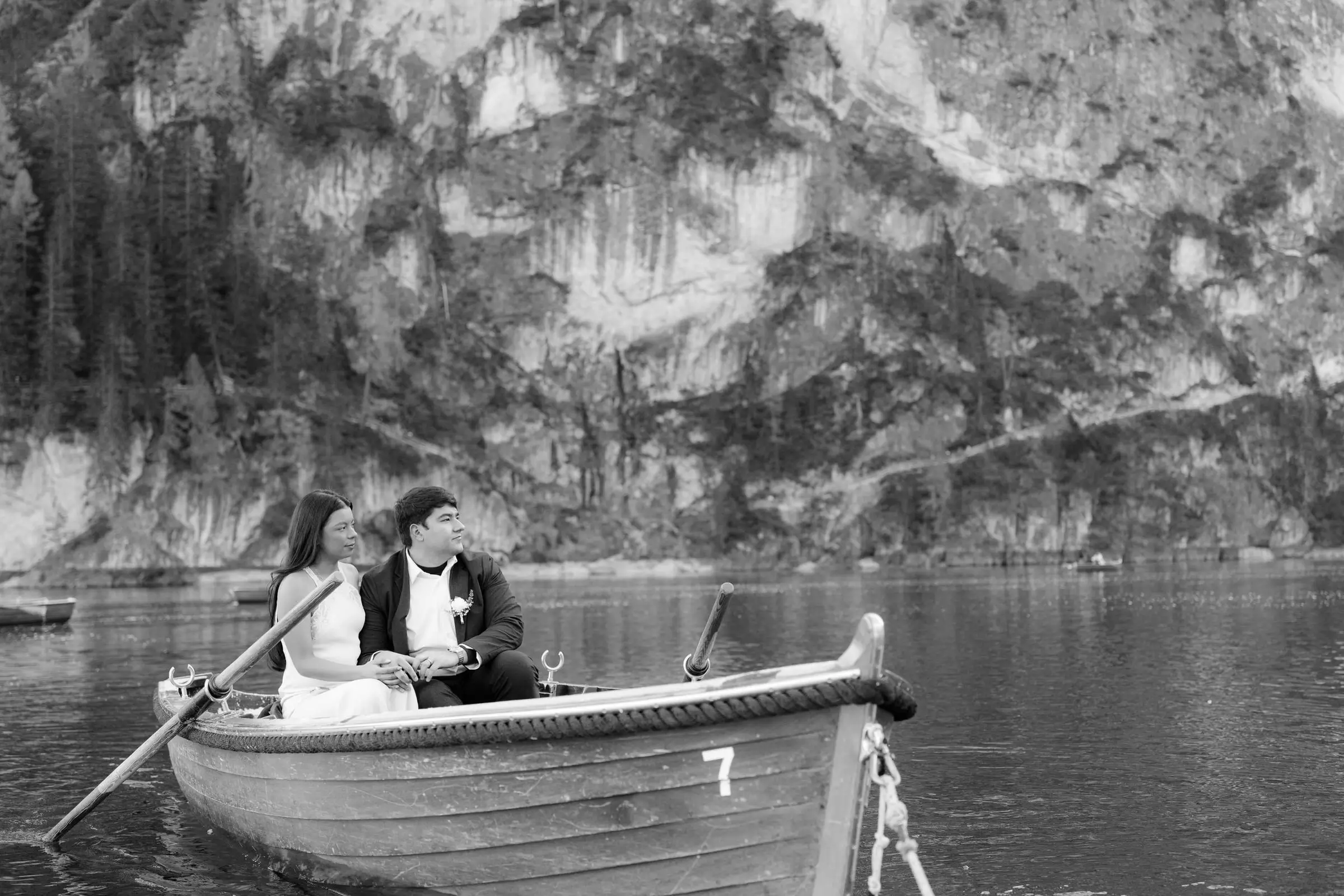 Black and white photo of the couple rowing across the lake