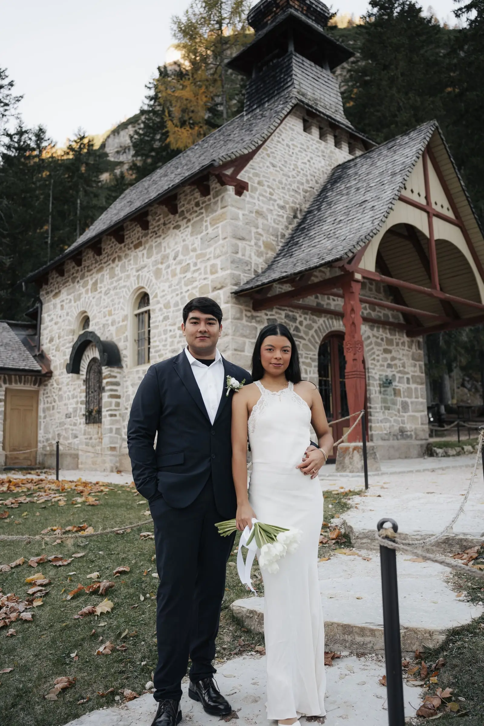 Couple in front of the little stone chapel at Lago di Braies