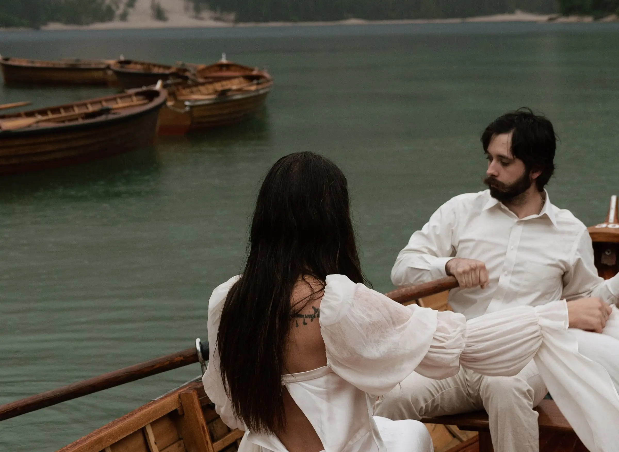 Couple sitting in a wooden rowing boat on the emerald lake