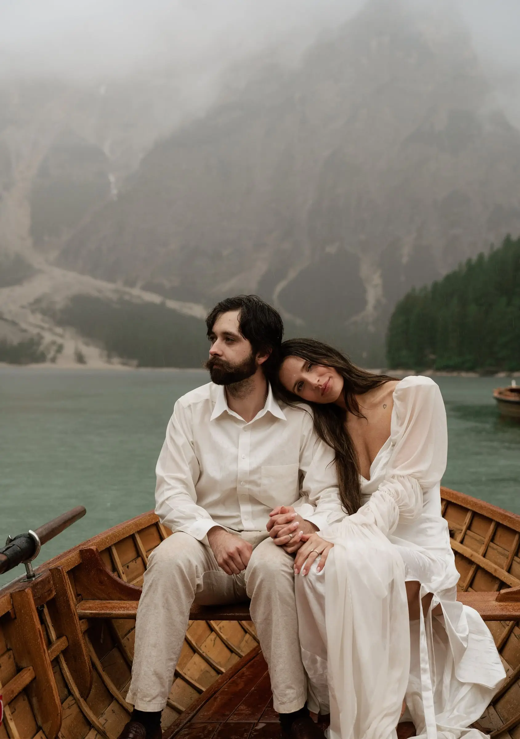 Bride resting her head on the groom's shoulder in a rowing boat