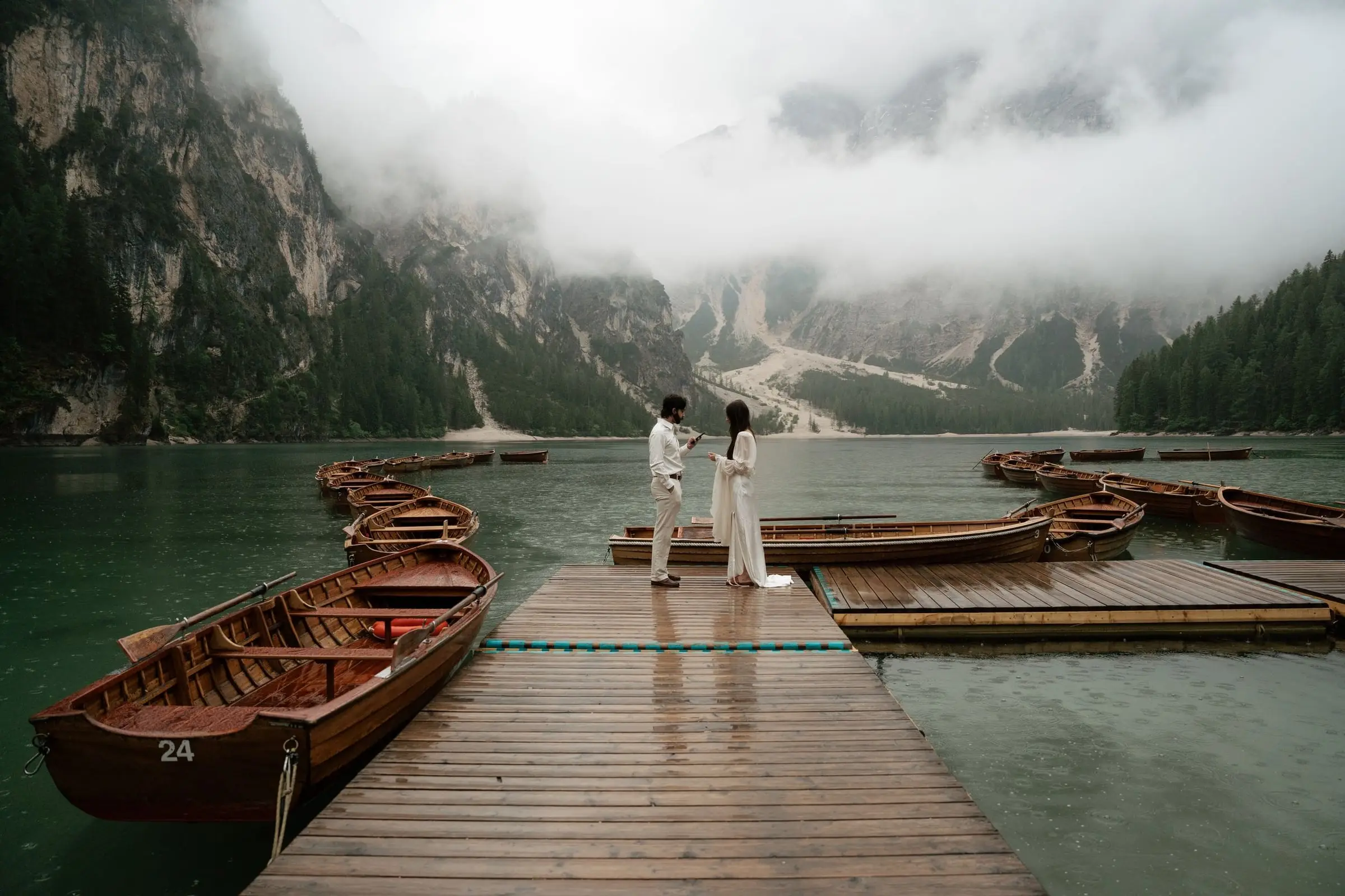 Couple exchanging vows on the jetty at Lago di Braies in the mist