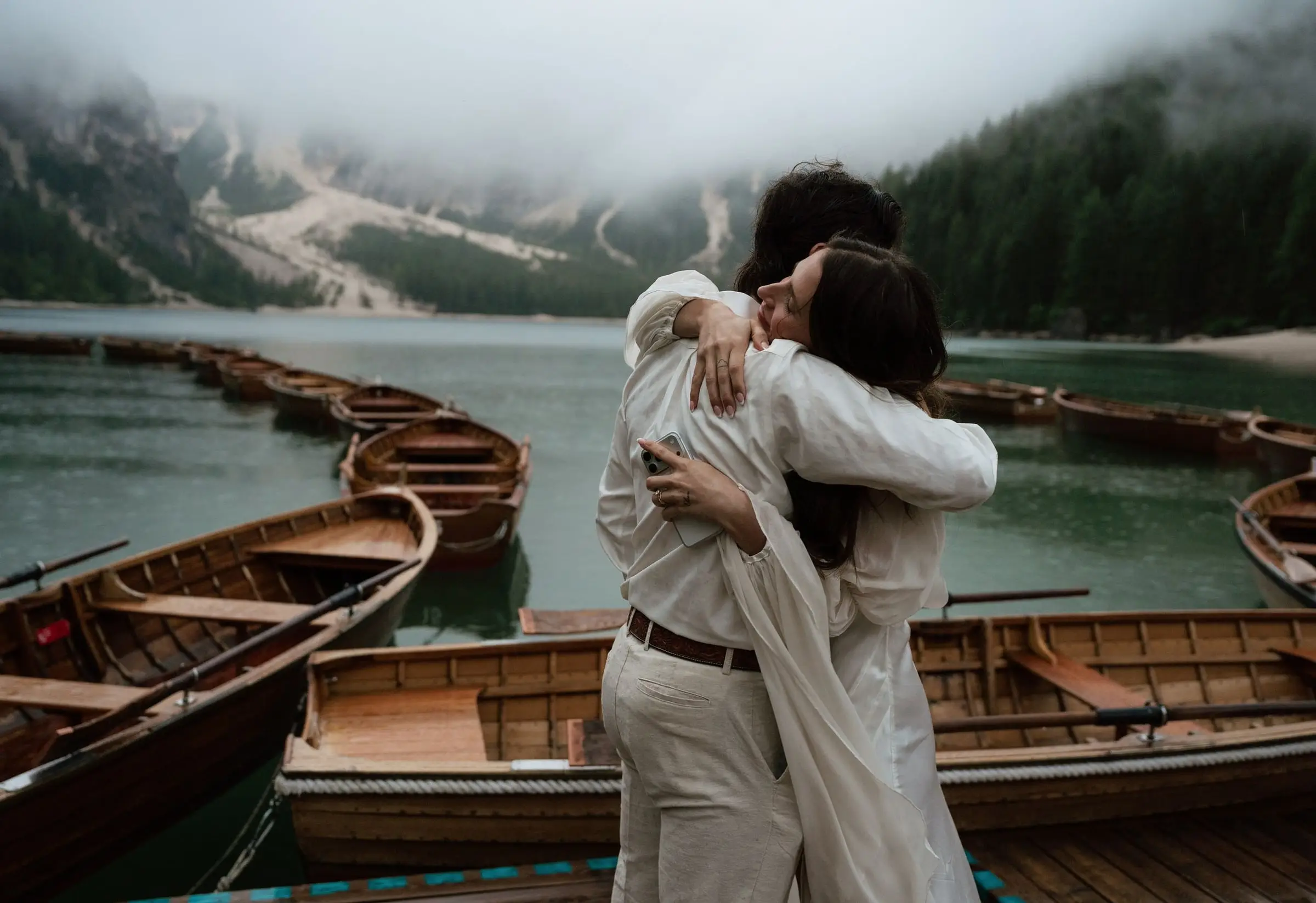 Couple hugging among the wooden rowing boats