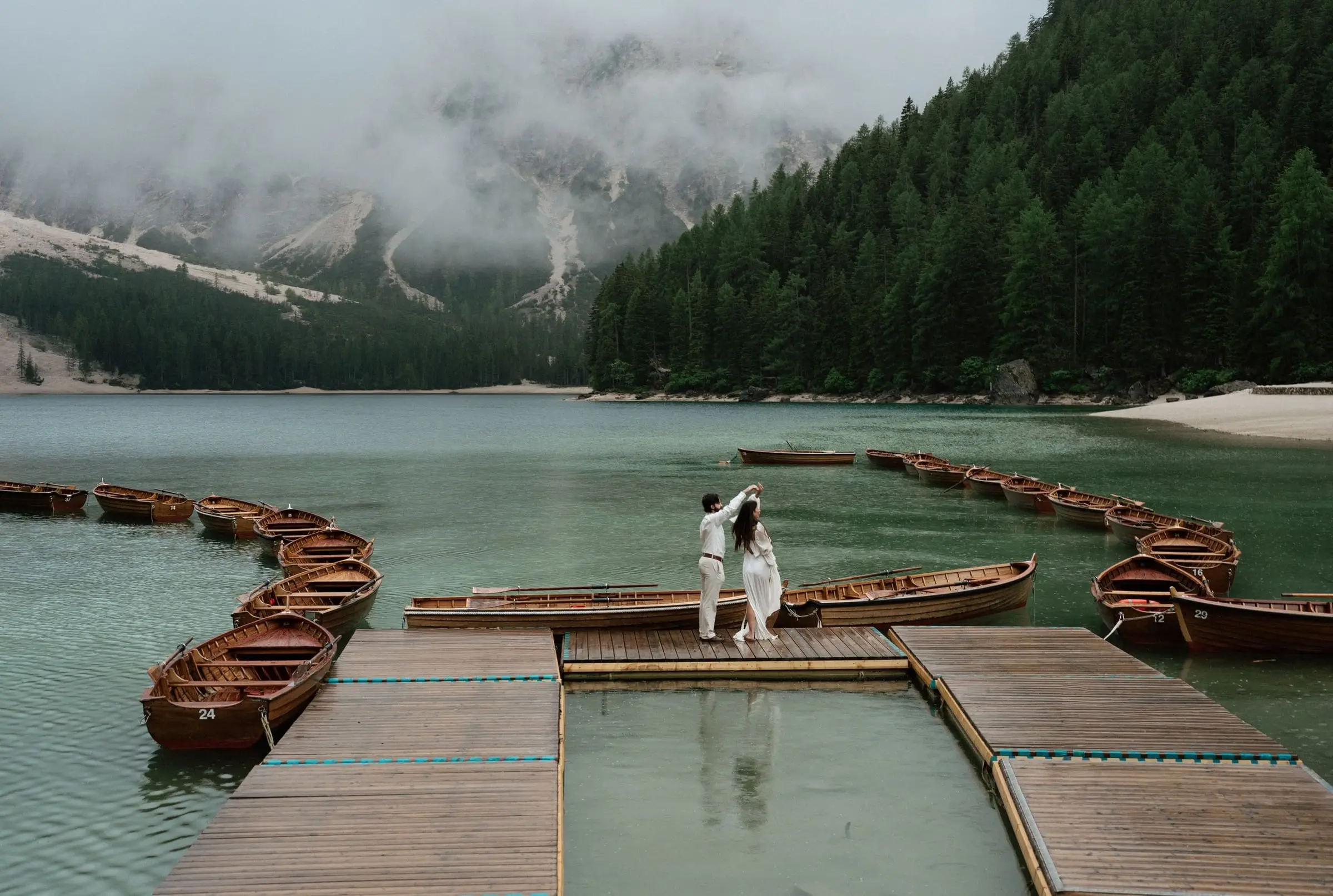 Couple dancing on the jetty between the boats of Lago di Braies