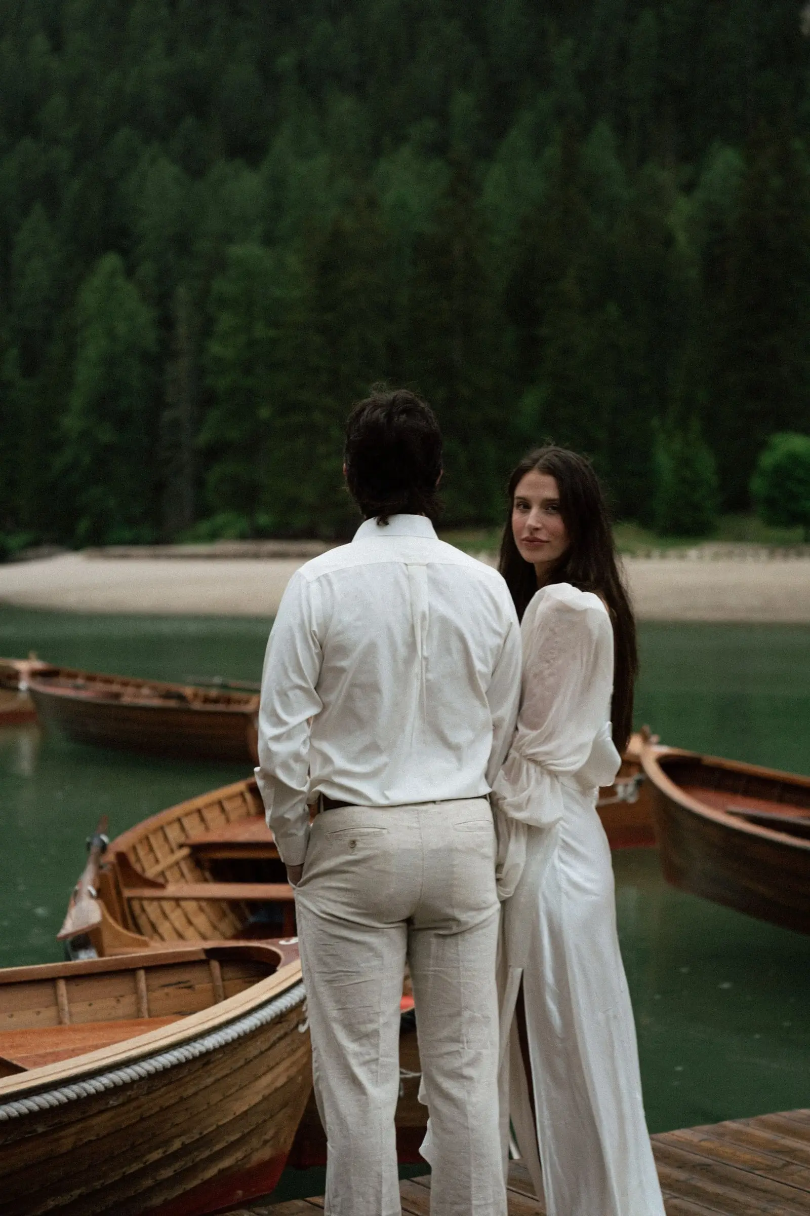 Bride looks over her shoulder beside the groom at the boats