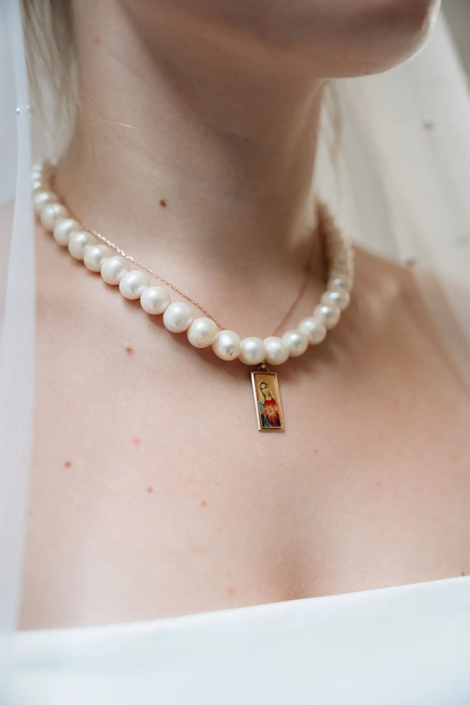 Close-up of the bride's pearl necklace with a small pendant