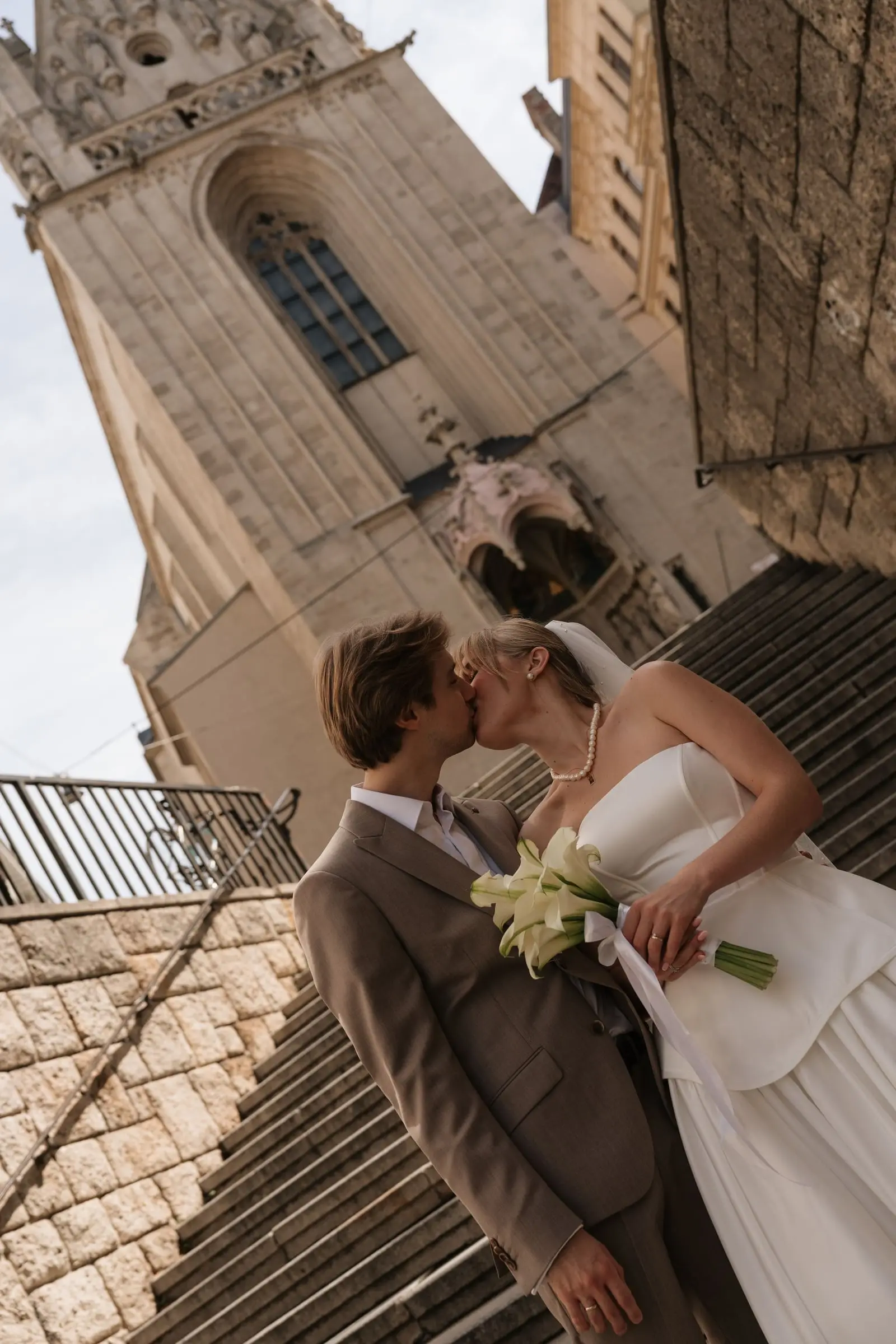 Couple kissing on the steps beside the Gothic tower of Maria am Gestade