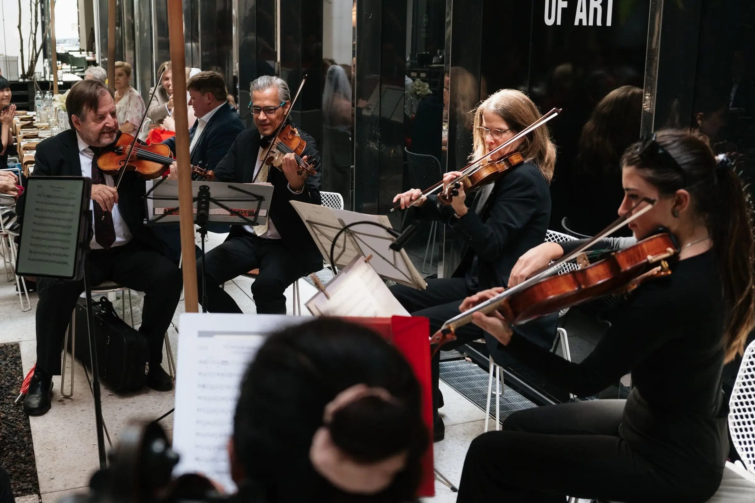 Small orchestra of violinists playing for the wedding guests
