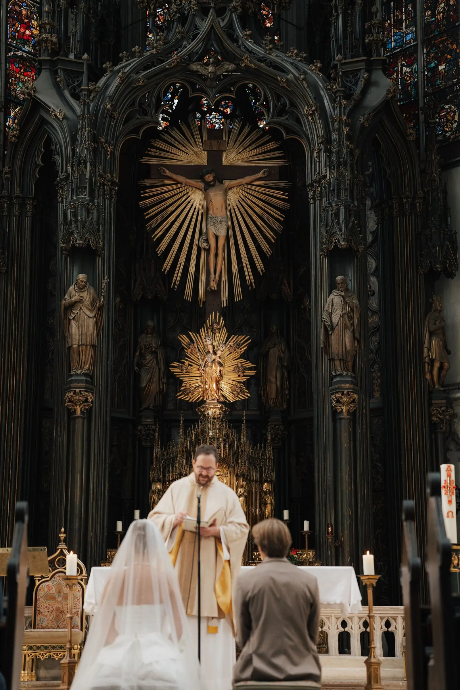 Bride and groom before the golden high altar of Maria am Gestade