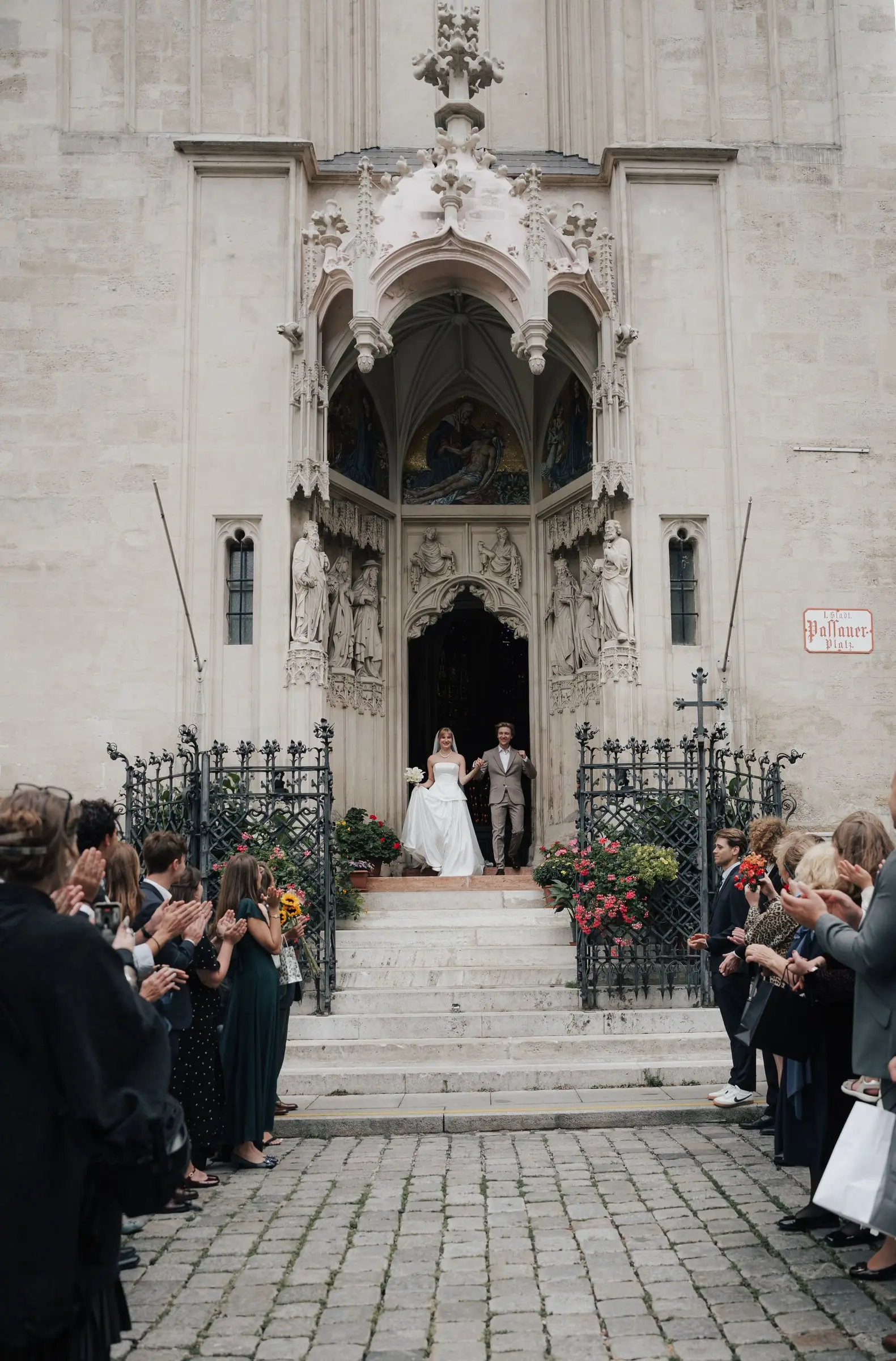 Newlyweds leaving the ornate Gothic portal of Maria am Gestade, guests lining the steps