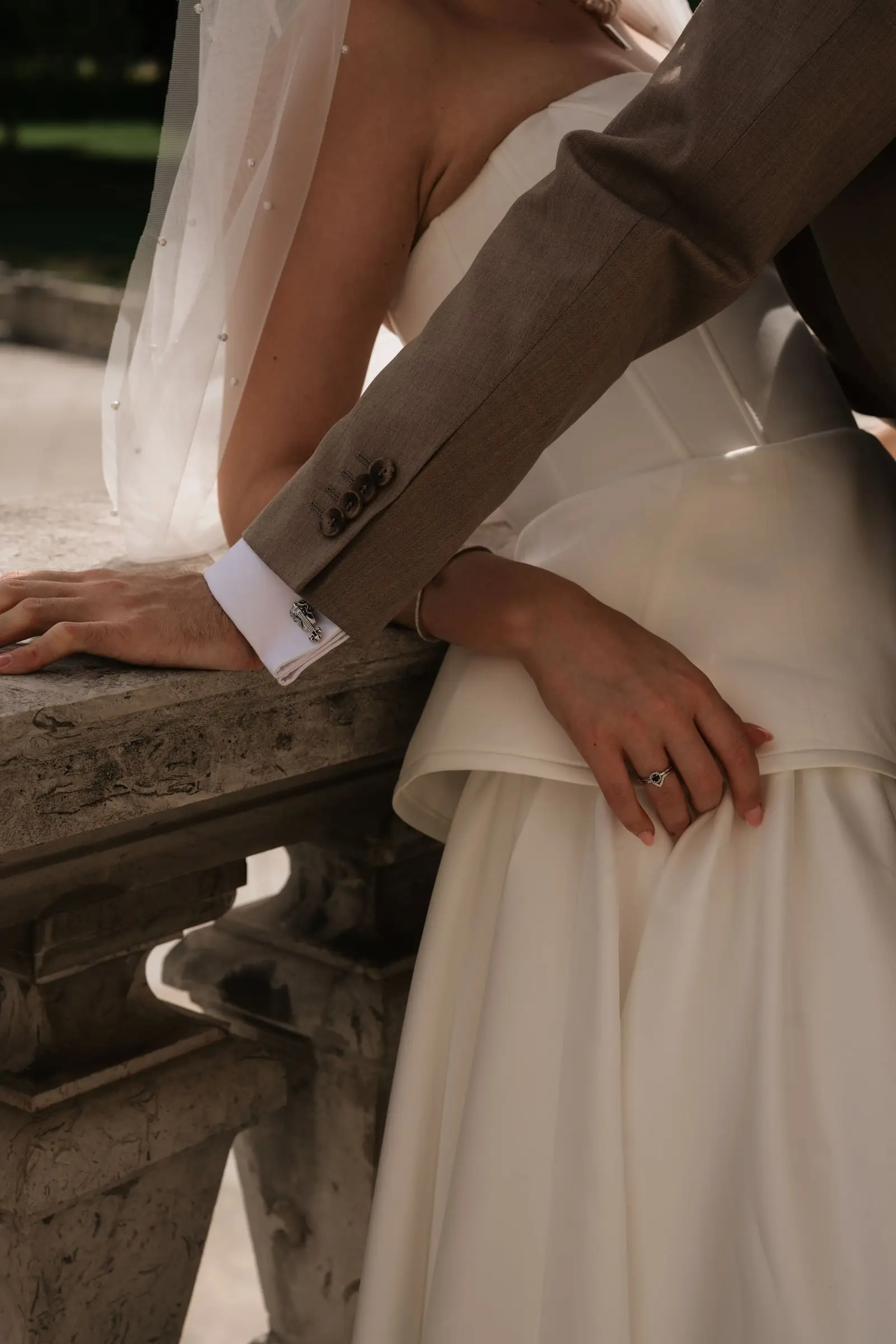 Detail of the groom's hand on the bride's waist at a stone balustrade