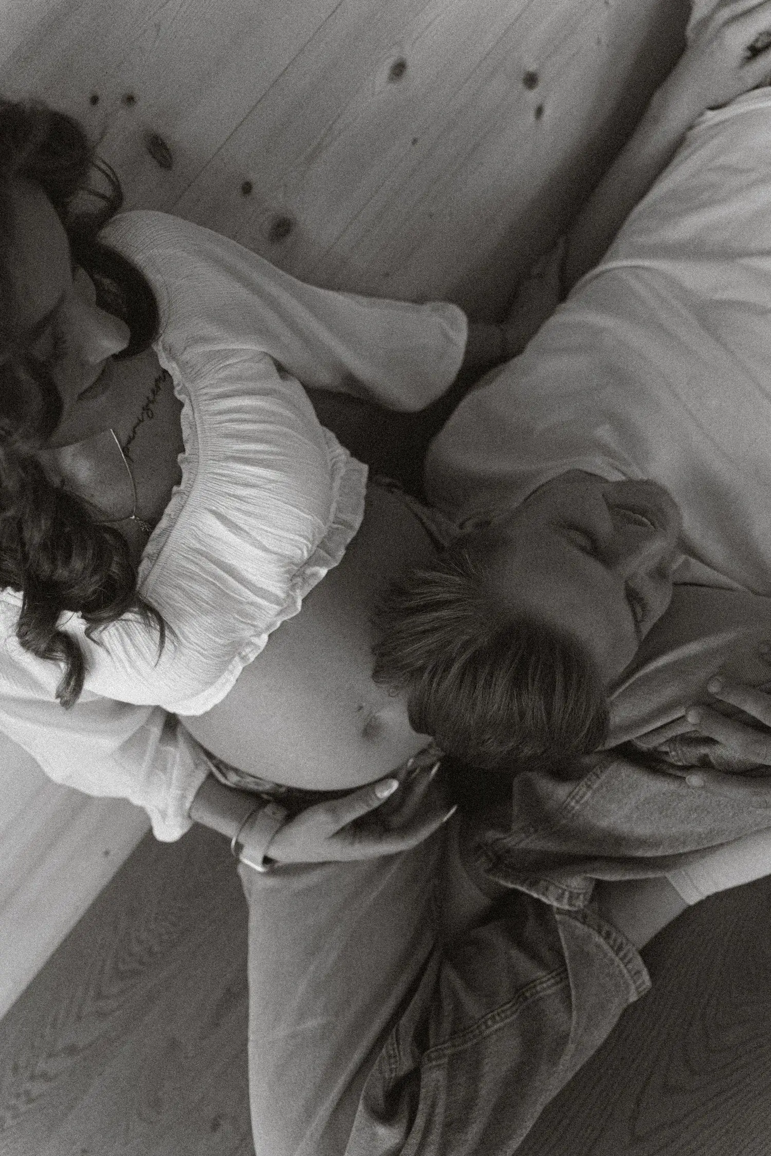 Black and white photo of the couple cuddled together from above