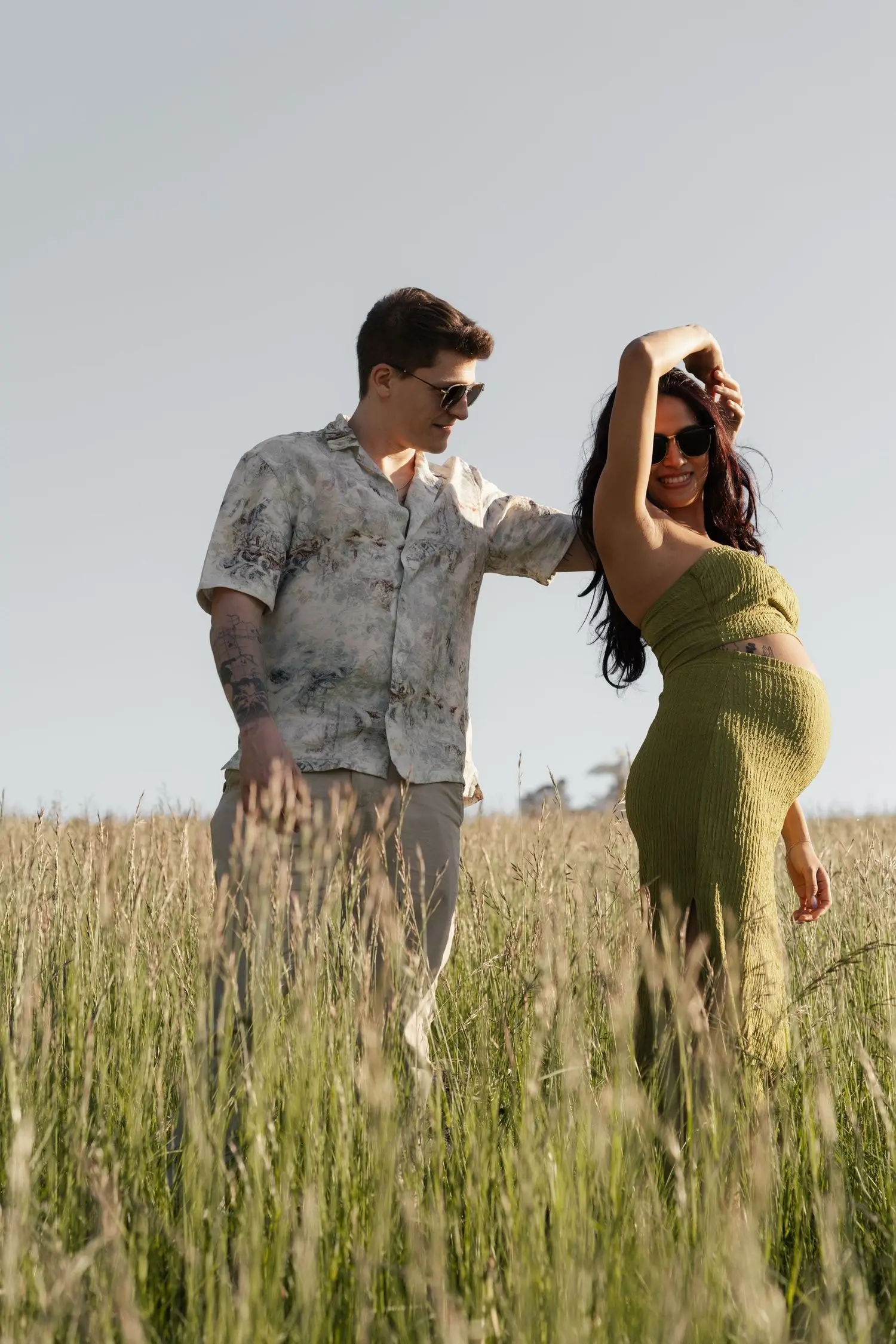 Couple in a meadow in Vienna, she in a green knit dress