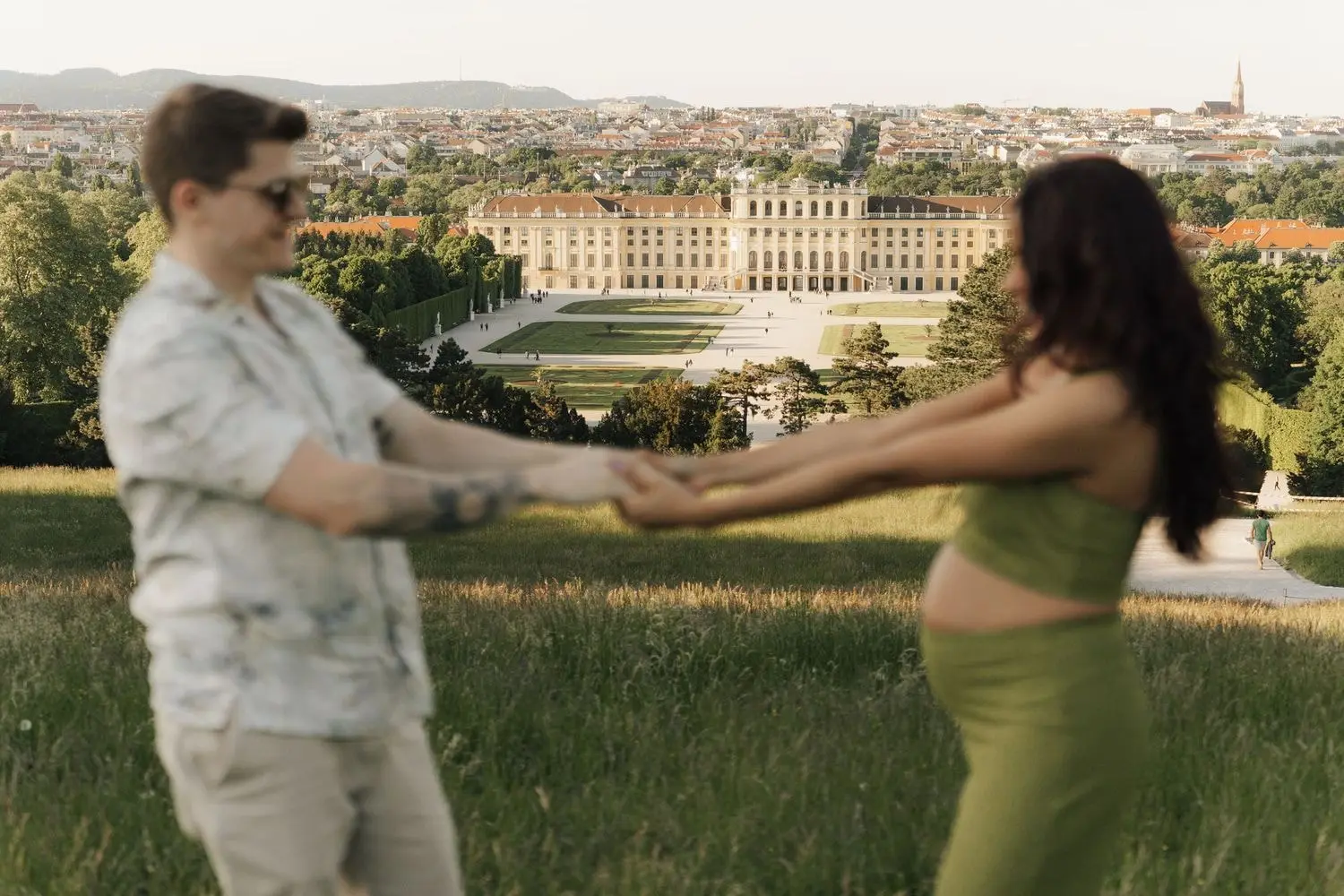 Couple spinning hand in hand above Schönbrunn Palace in Vienna