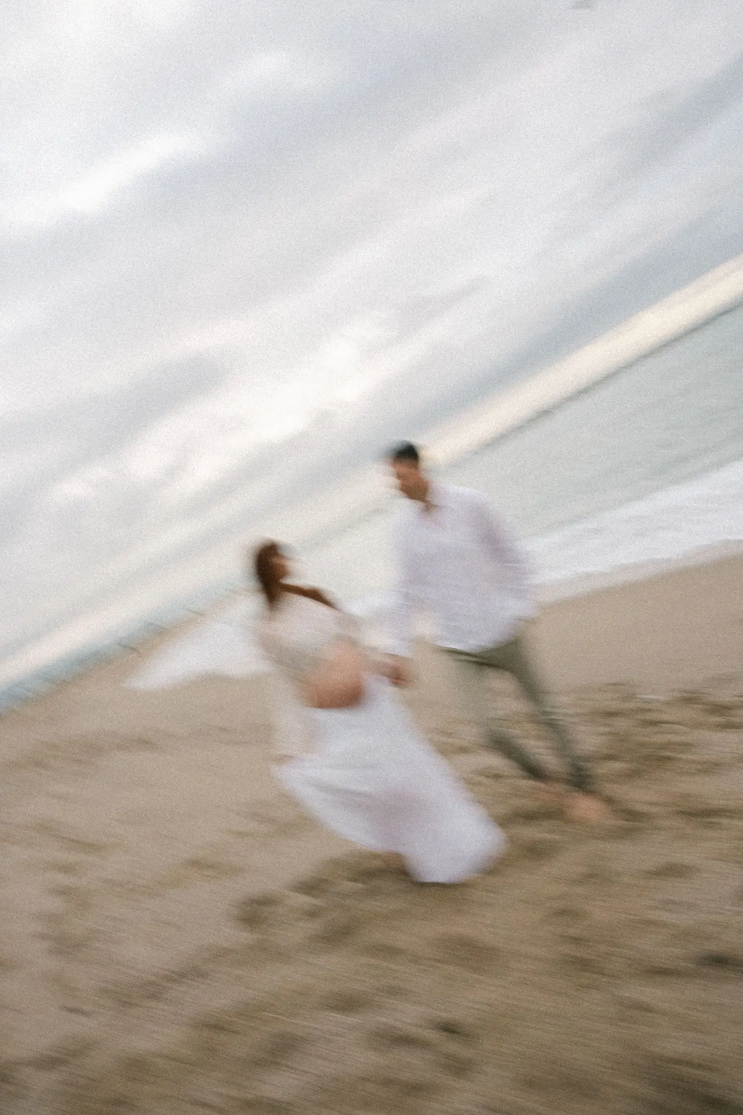 Couple running along the beach, motion blur