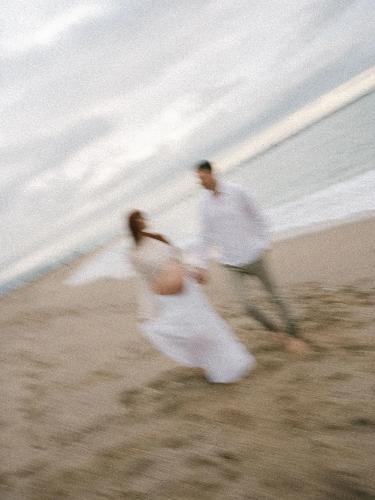 Couple running along the beach, motion blur