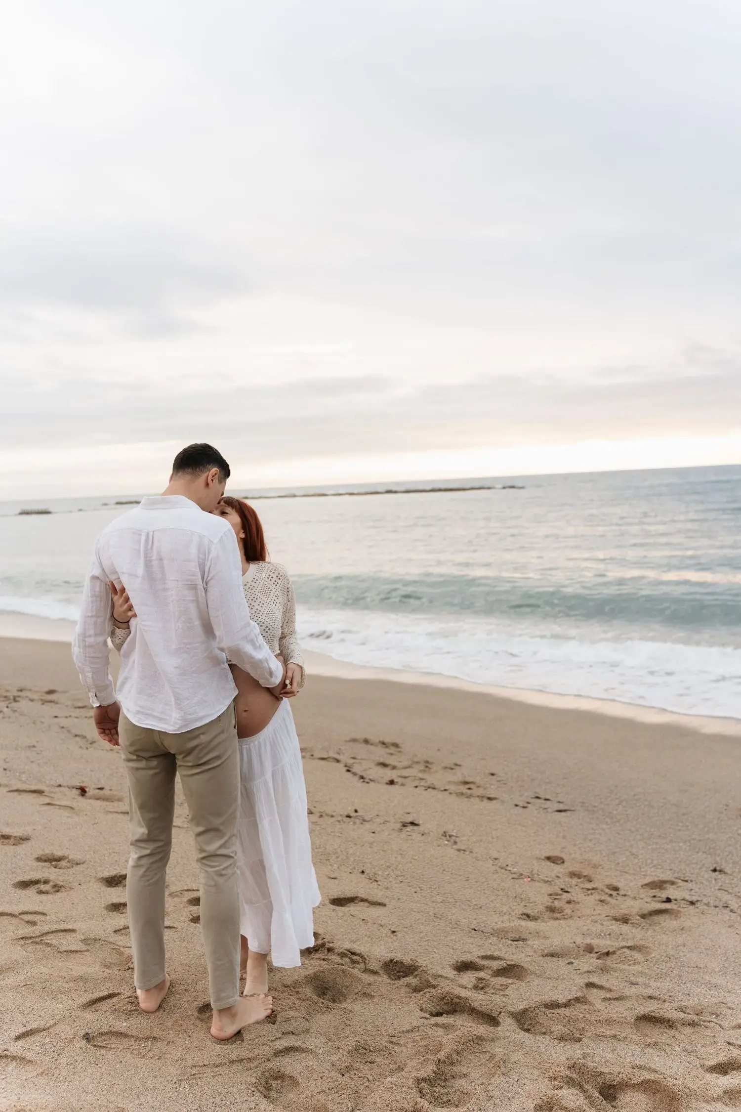 Couple embracing on the beach at sunrise