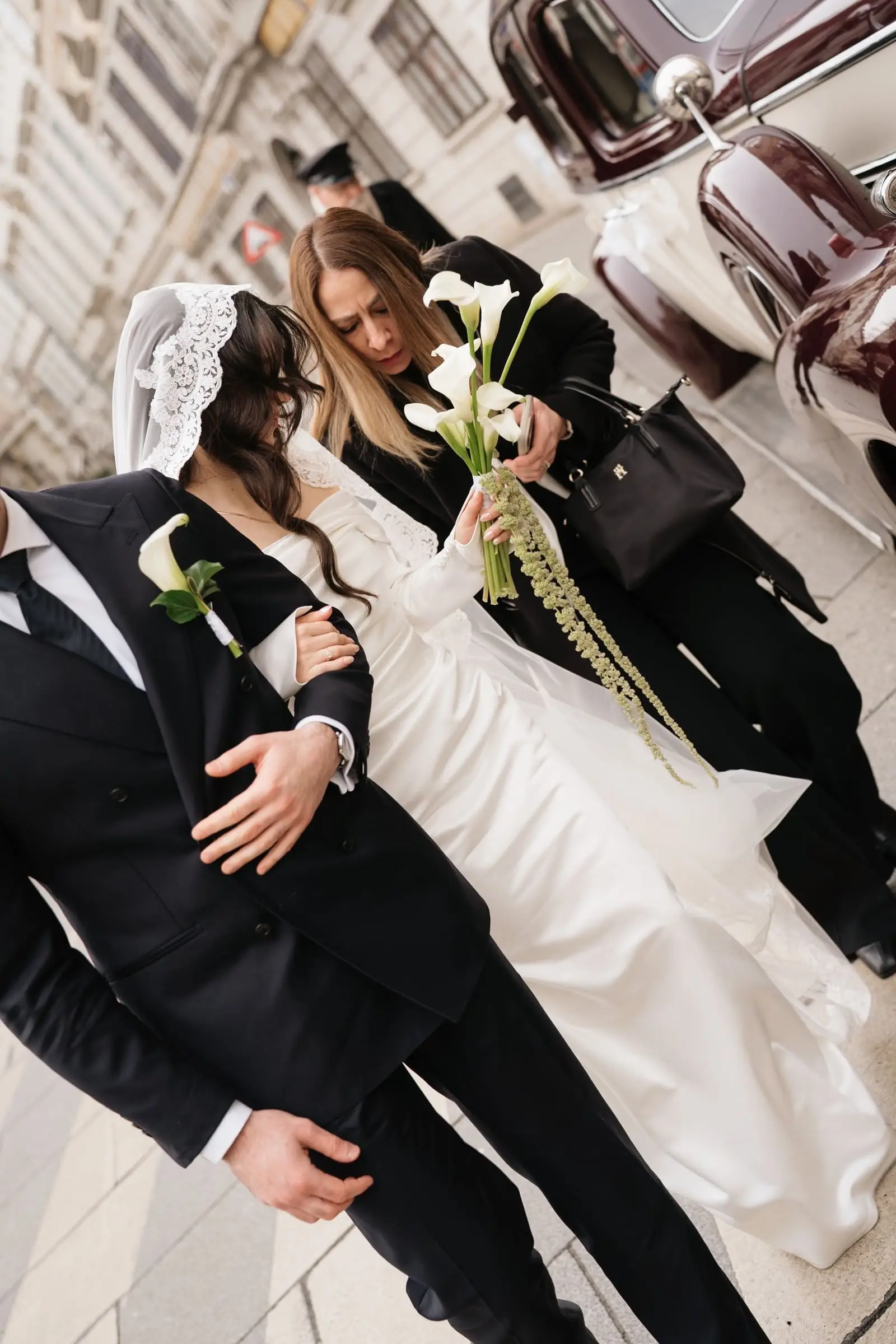 Couple arriving through the guests, the bride in a lace mantilla veil