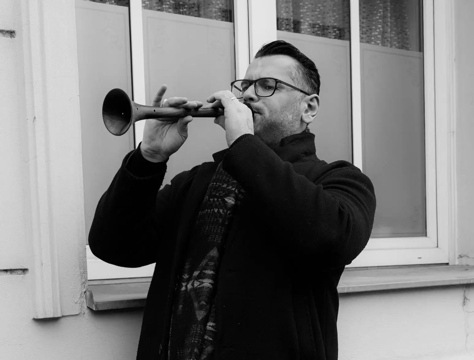 Black and white photo of a musician playing a traditional zurna