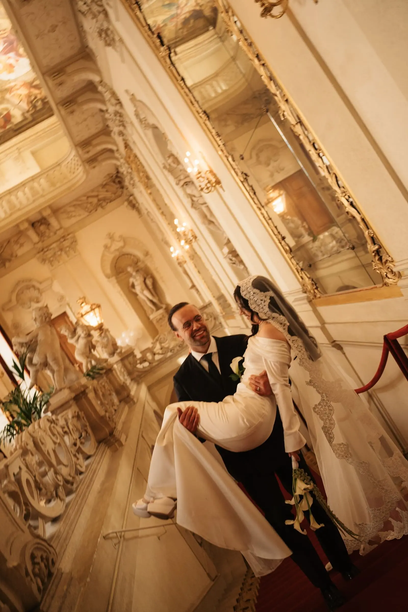 Groom carrying the bride through a golden hall of the palace