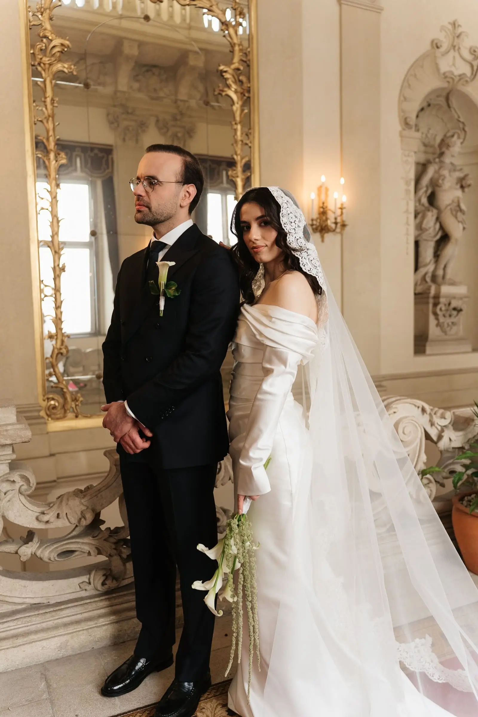 Couple standing in front of a gilded mirror in the baroque palace