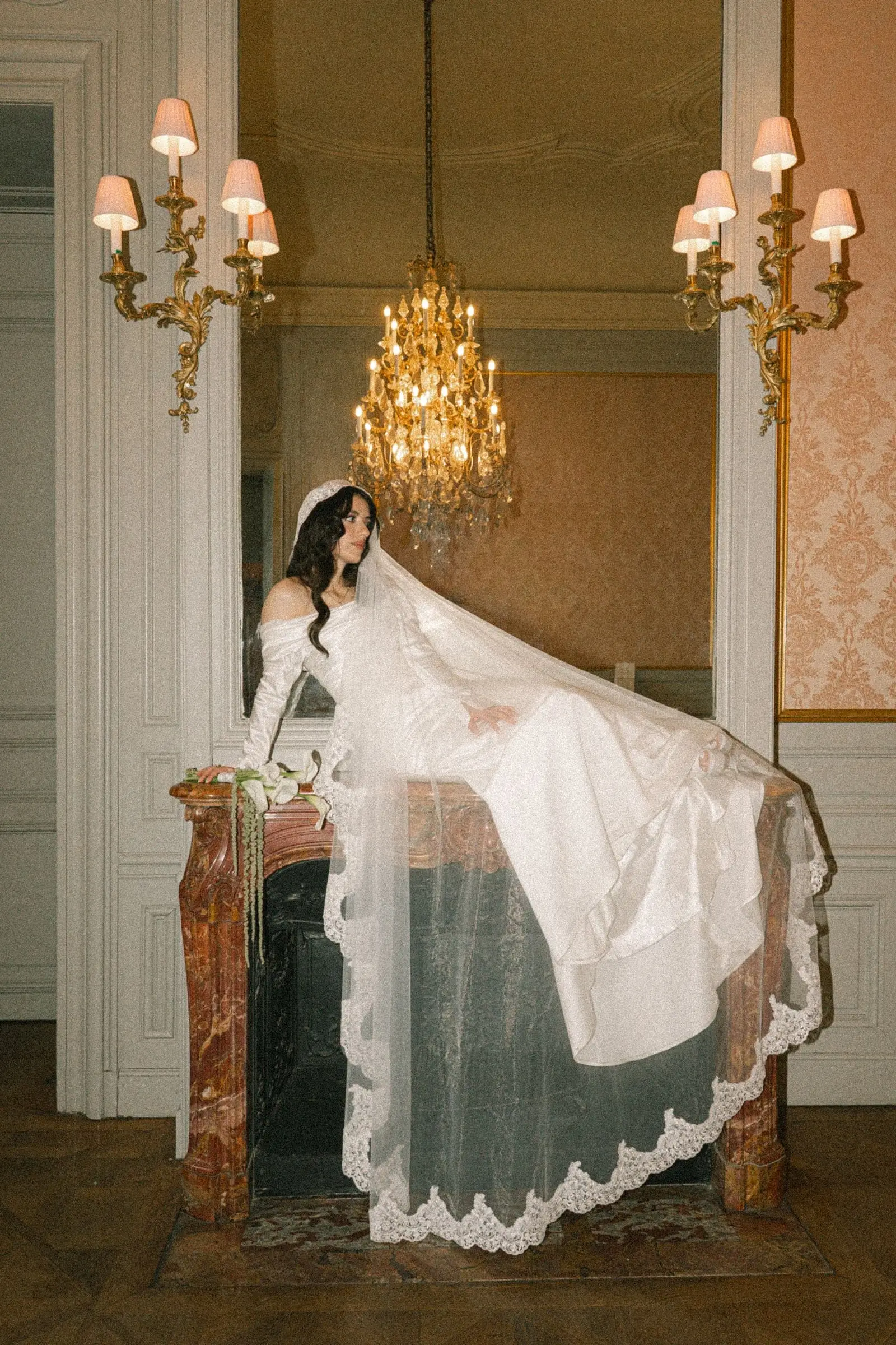 Bride on the marble fireplace with her veil spread out
