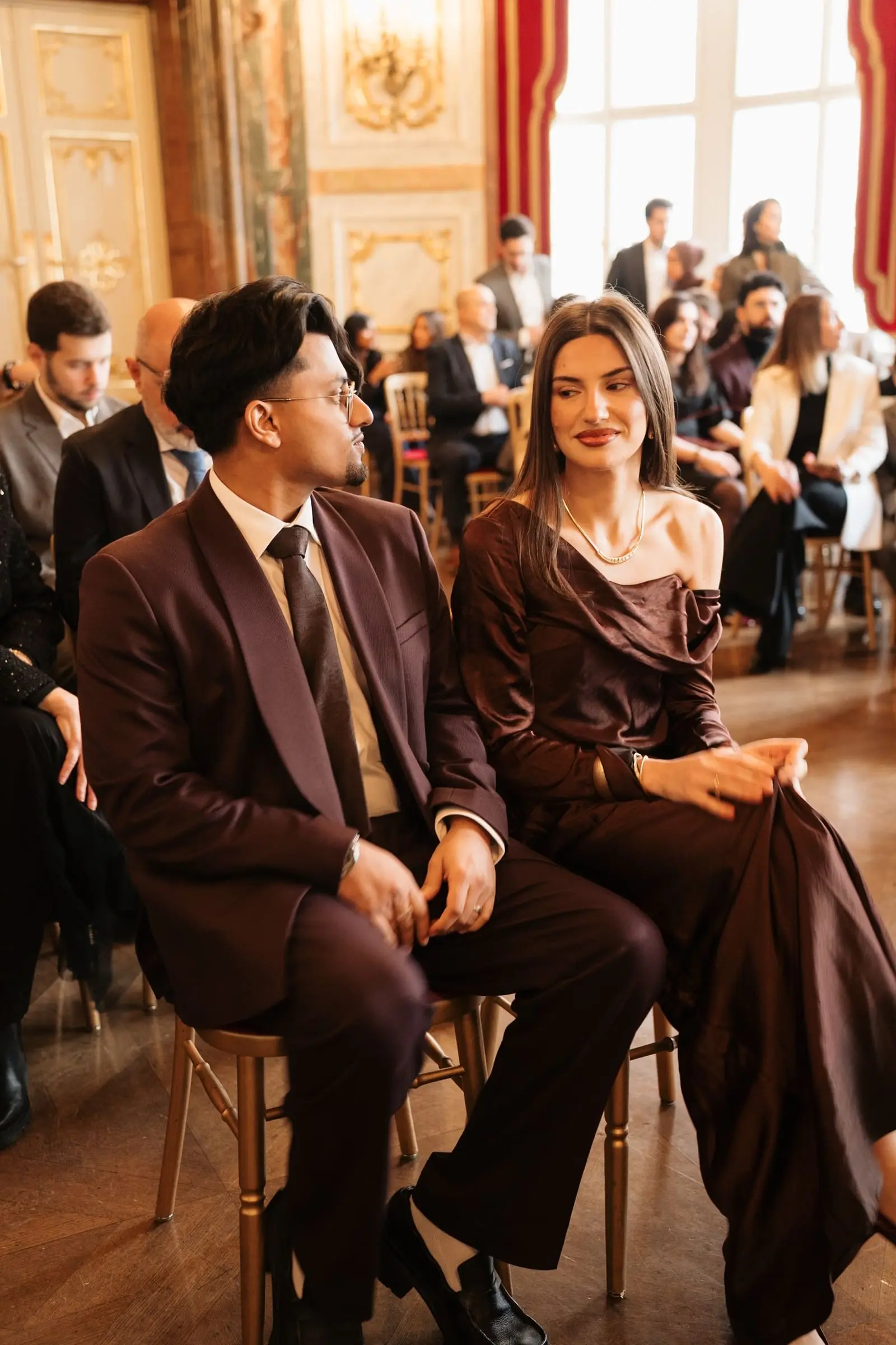 Guests seated in the gilded ceremony hall