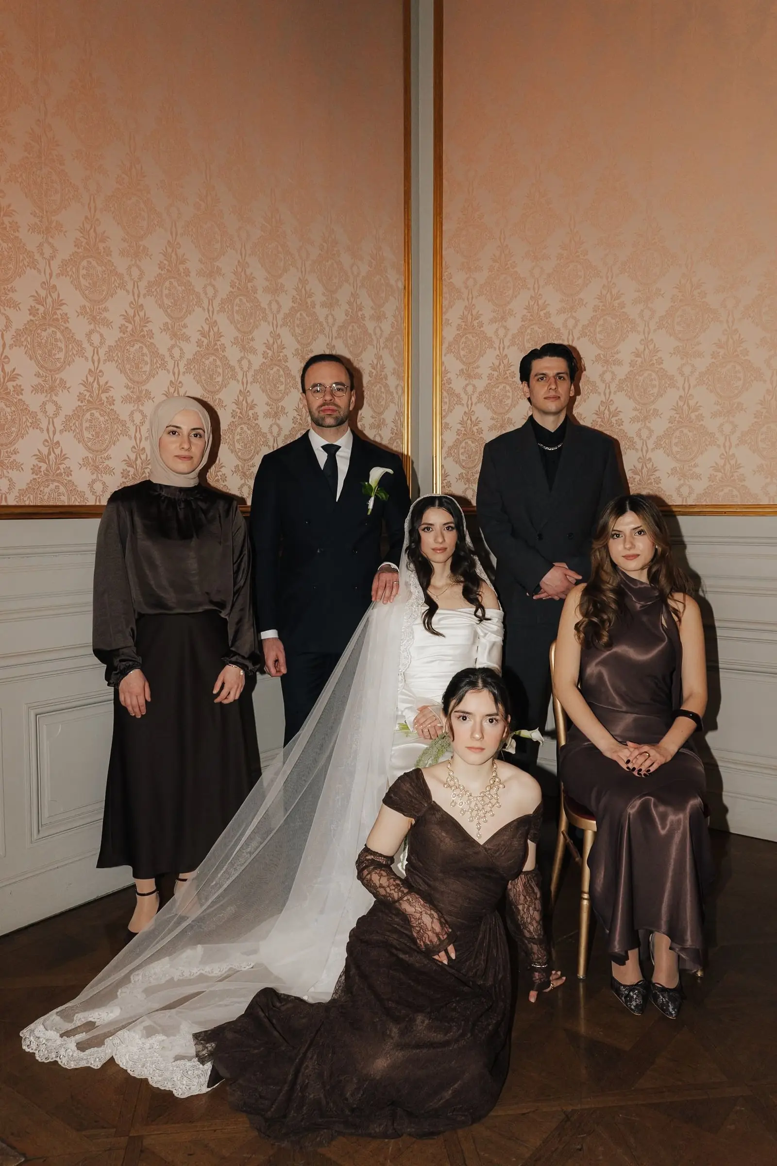 Family portrait with the bride and groom in a damask-walled room