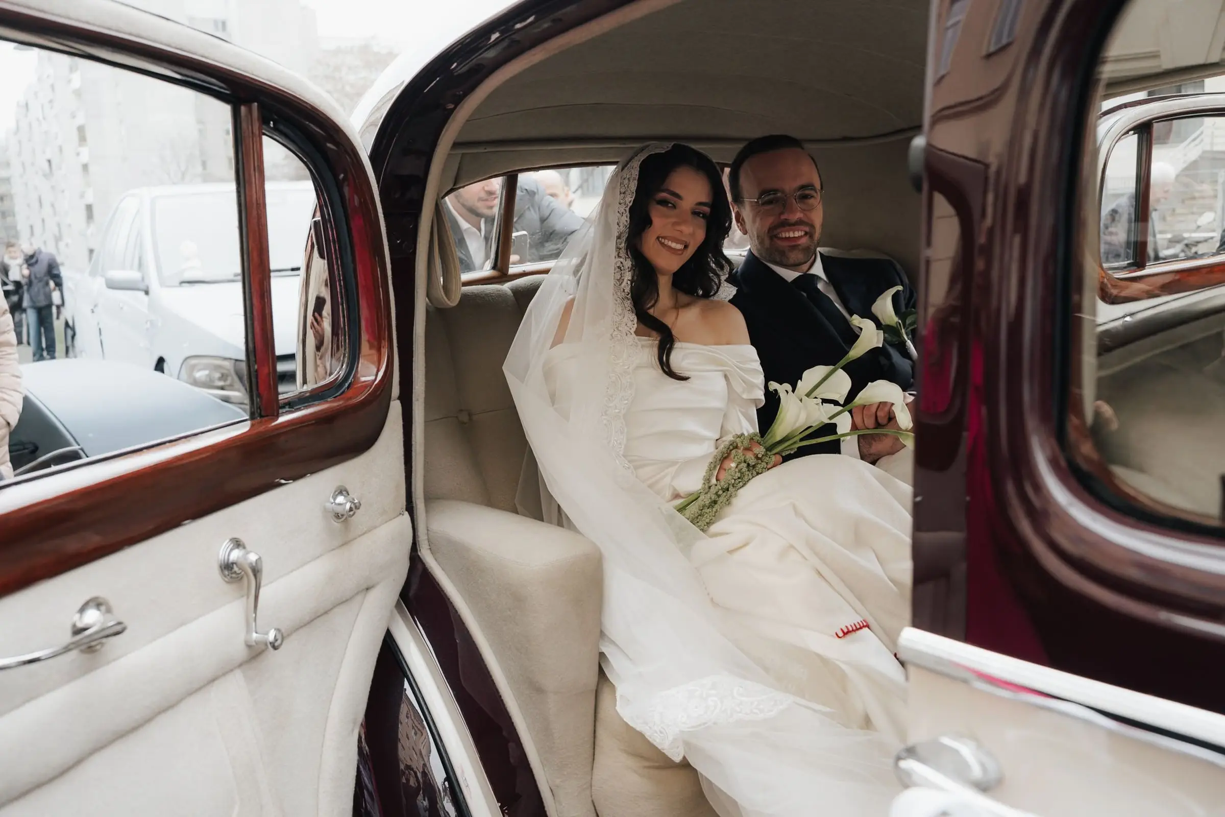Couple in the back of a vintage car, seen through the open door