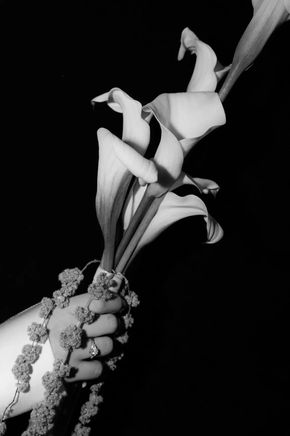 Black and white detail of the calla lily bouquet in the bride's hand