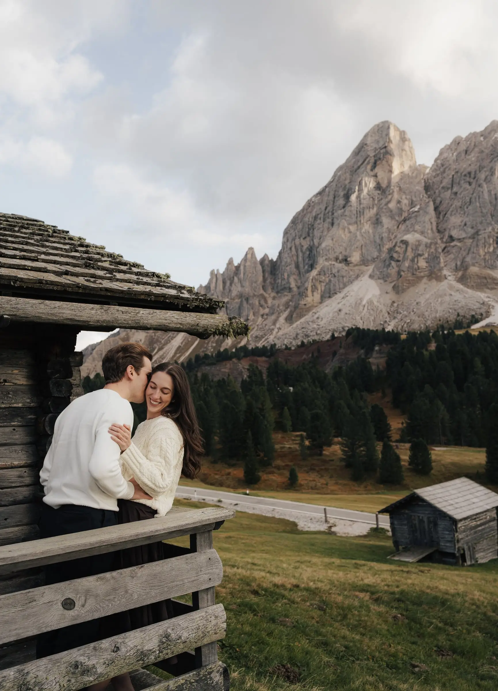 Couple embracing on the balcony of a hut, the Sass de Putia behind