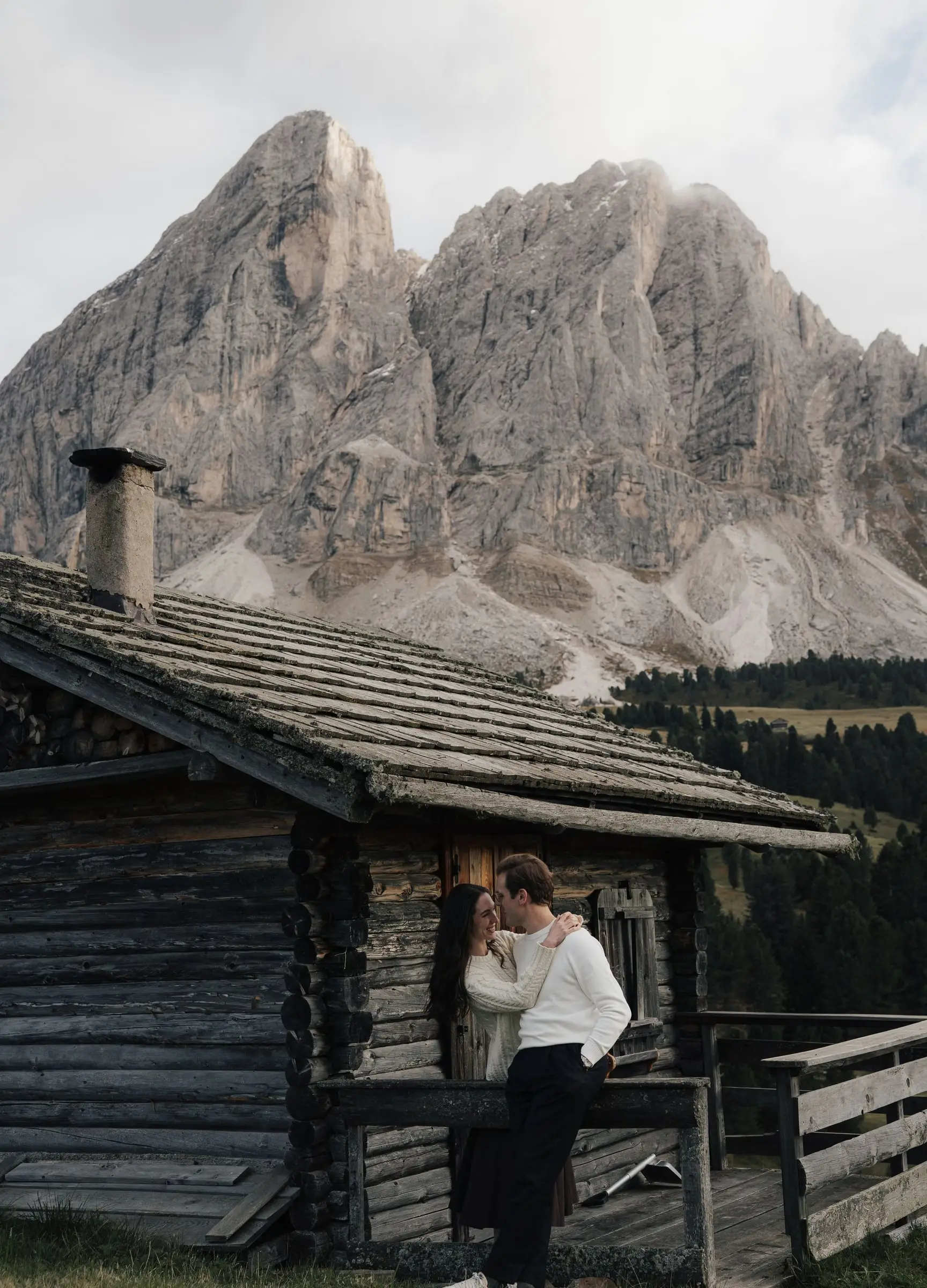 Couple kissing against the log wall of a hut below the Sass de Putia
