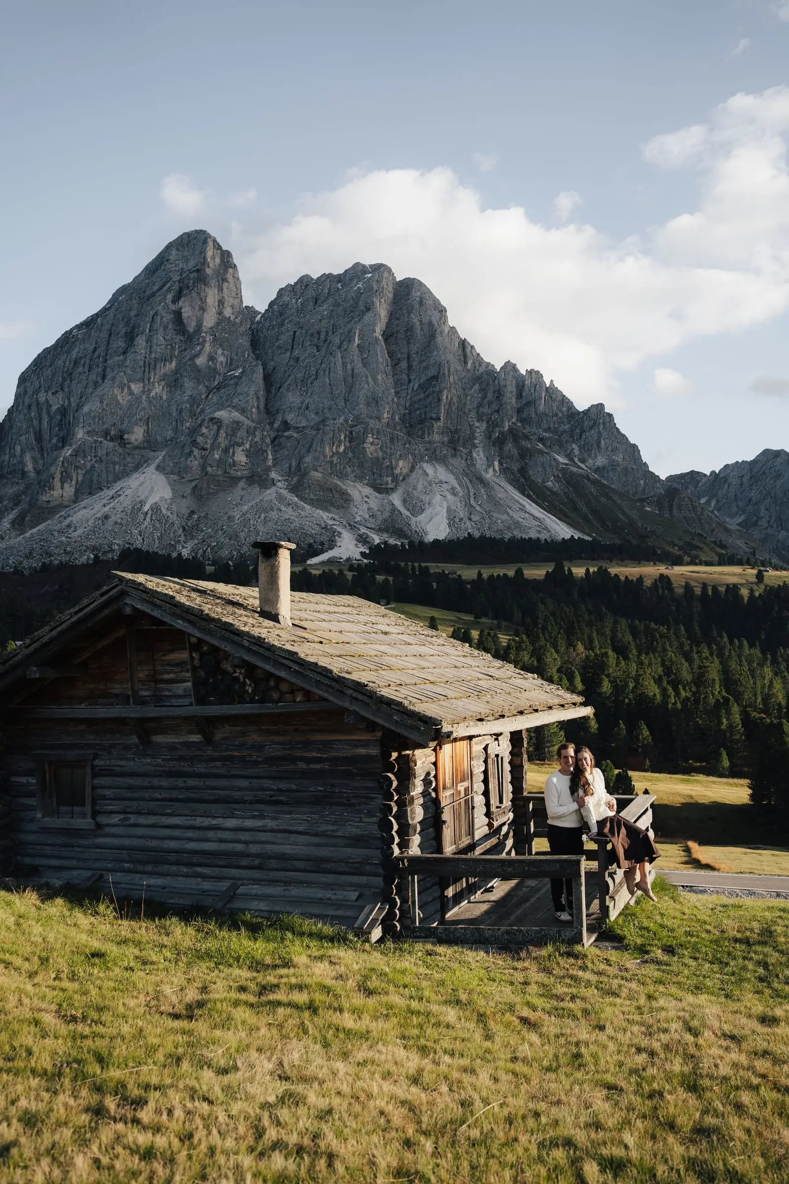 Old wooden hut below the Sass de Putia, the couple on its porch