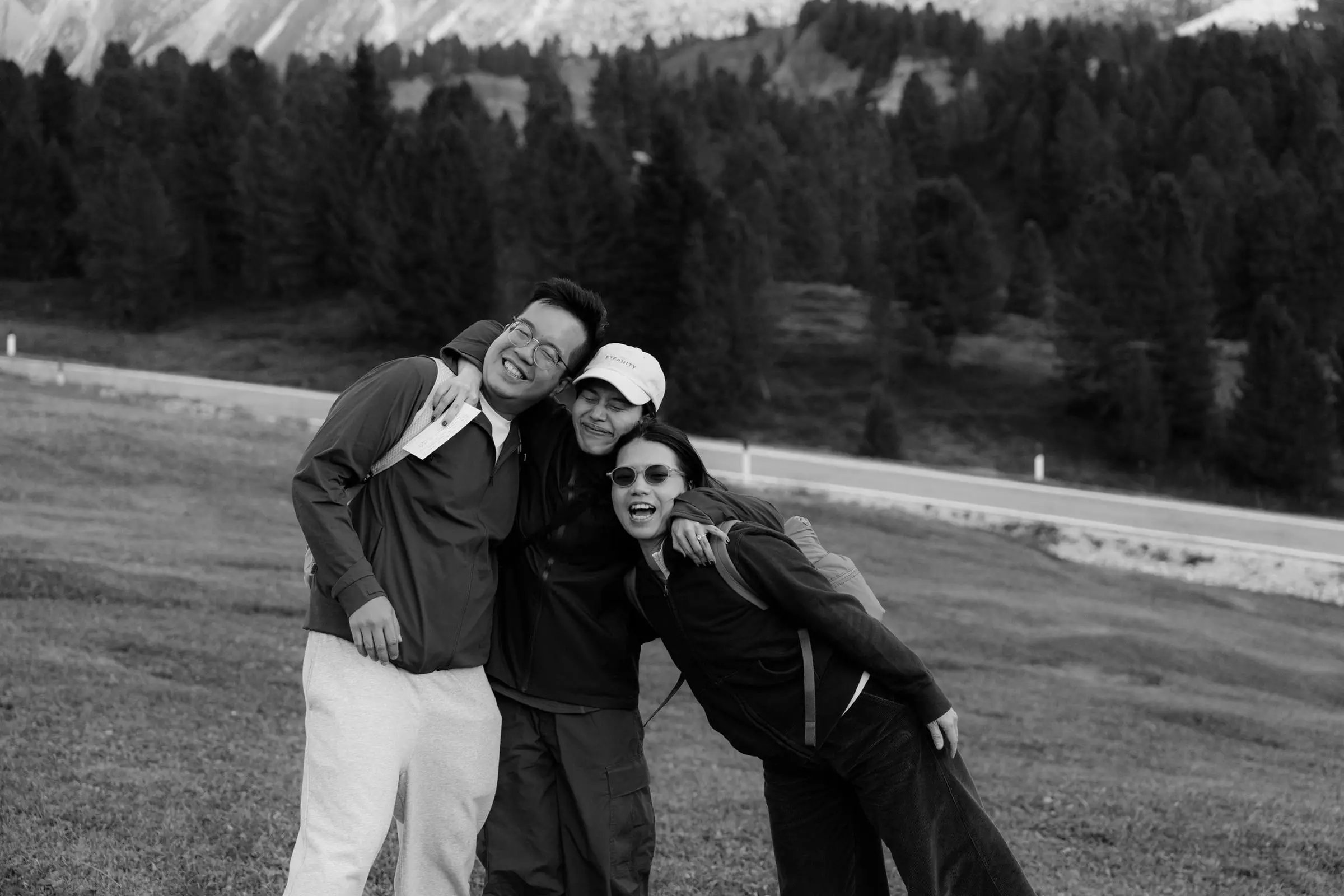 Black and white photo of the newly engaged couple laughing with a friend