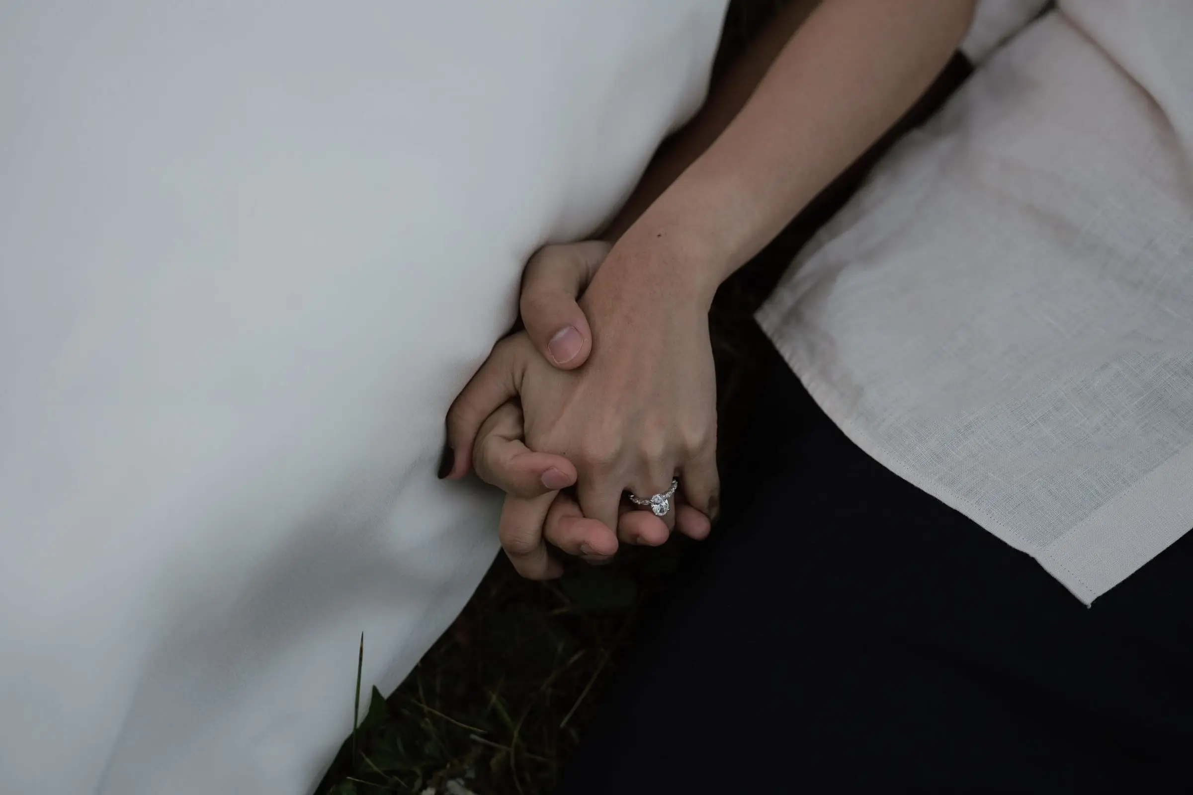 Close-up of their joined hands with the engagement ring