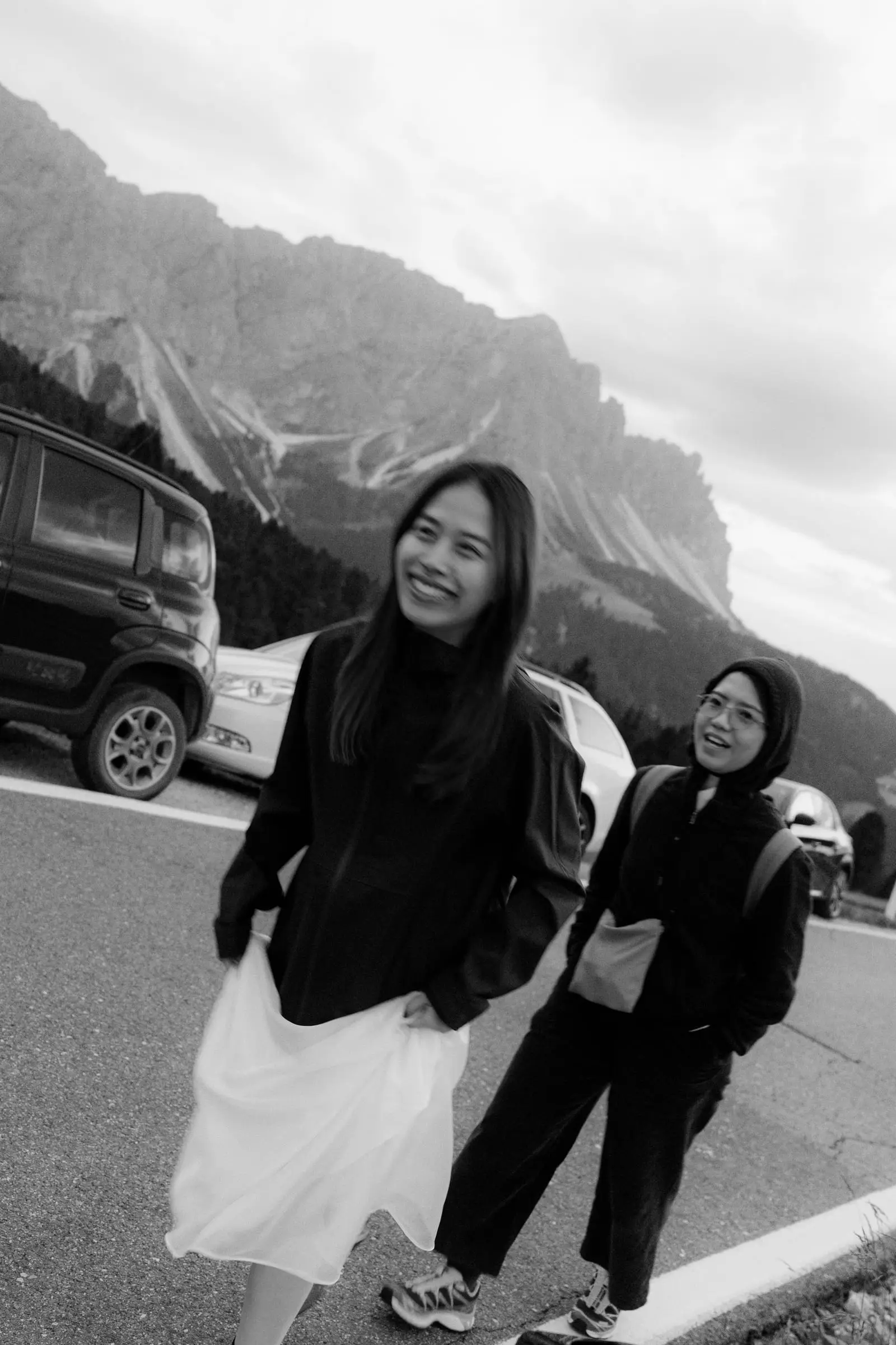 Black and white photo of her and a friend laughing on the pass road