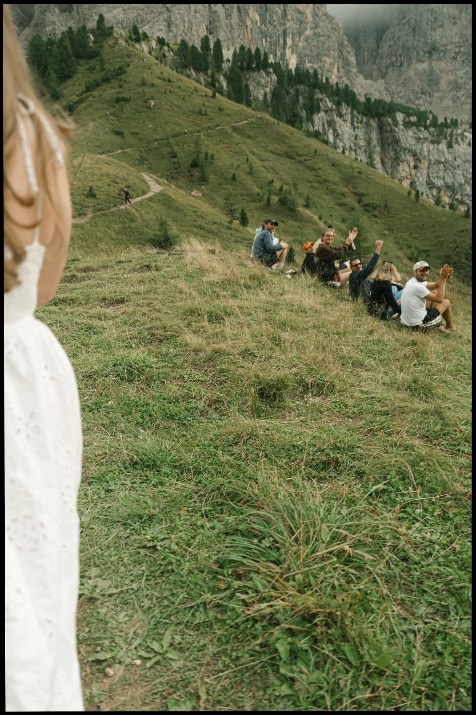 Hikers resting on the meadow below the Cir peaks, the bride's dress in the foreground