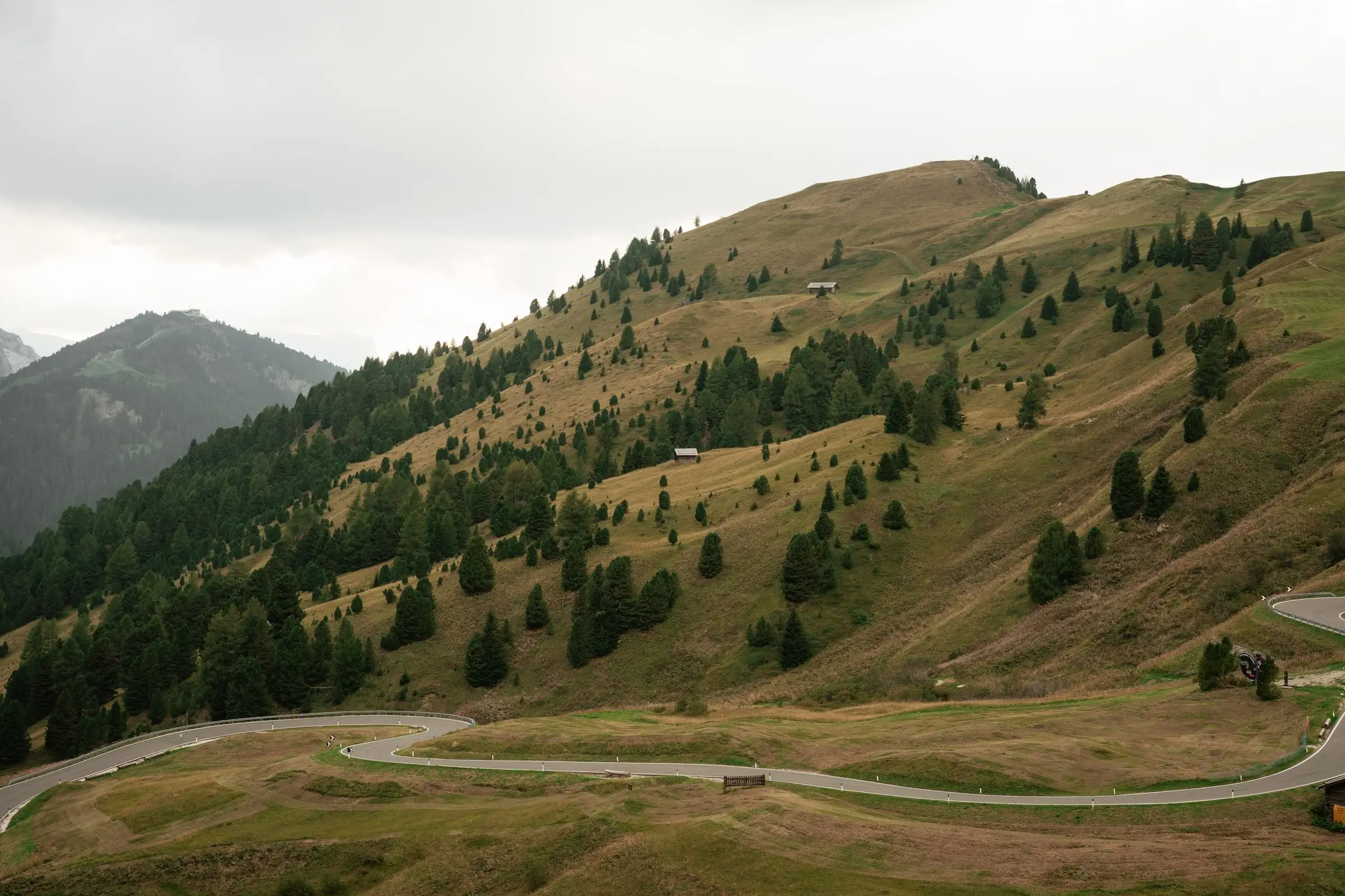 Green hills and the winding road of Passo Gardena