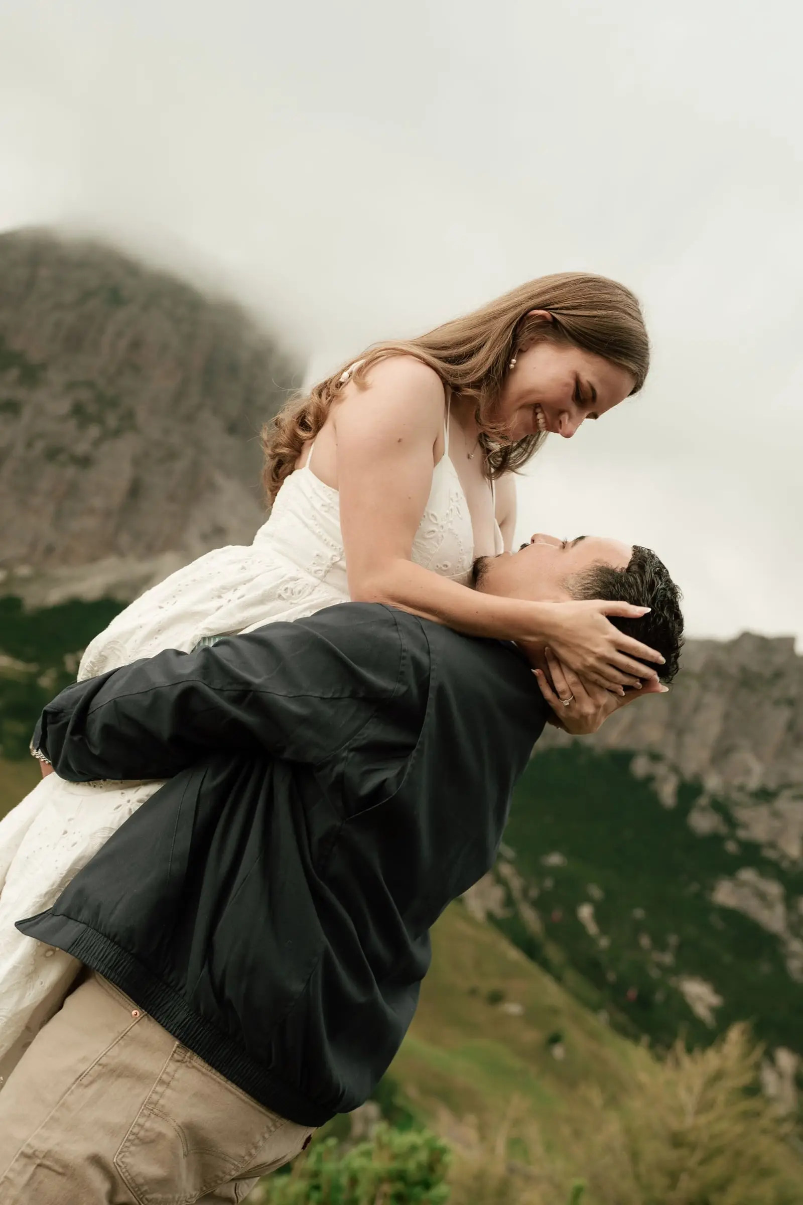 He lifts her as she holds his face and smiles
