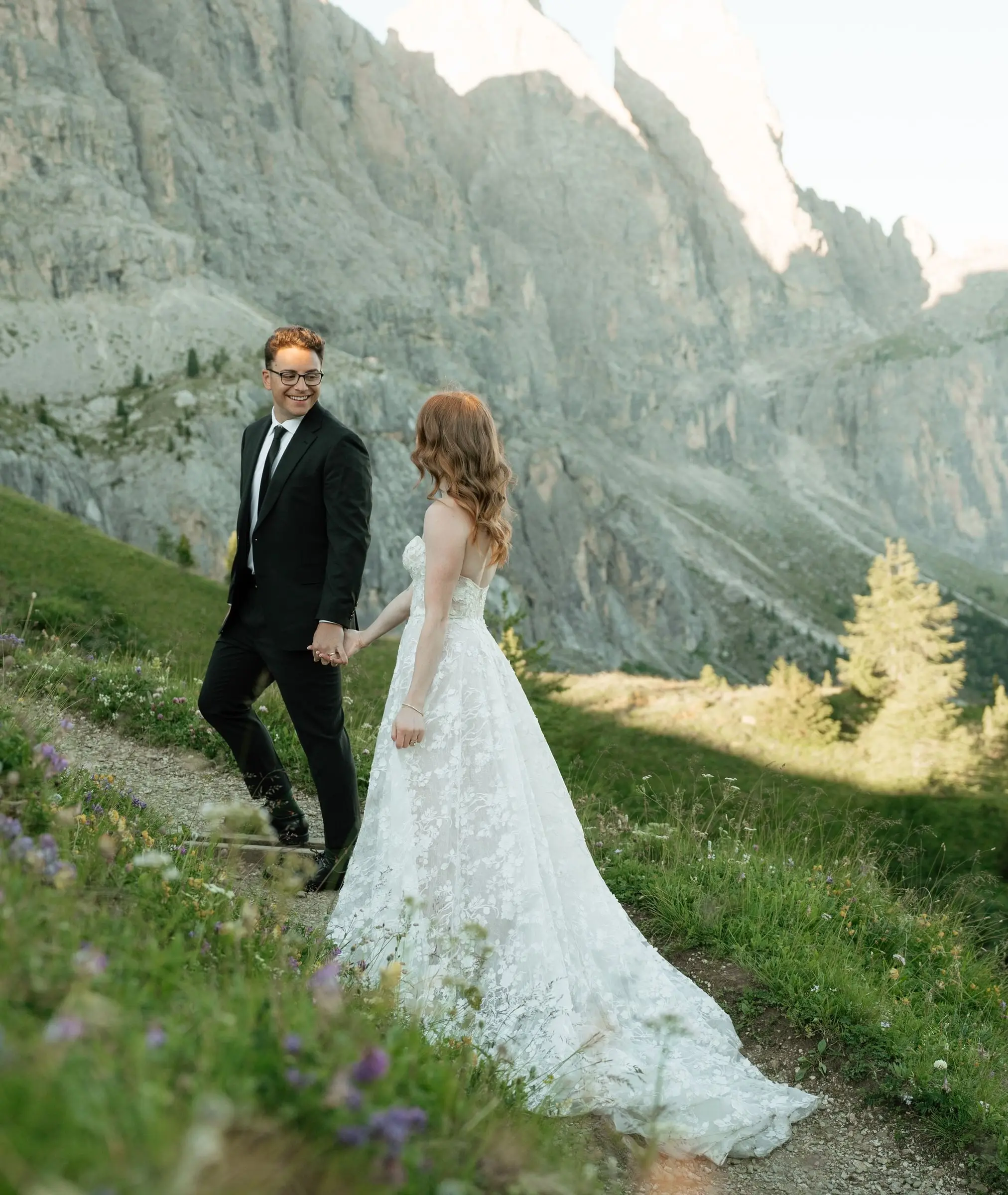 Couple walking hand in hand along the trail below the rock walls