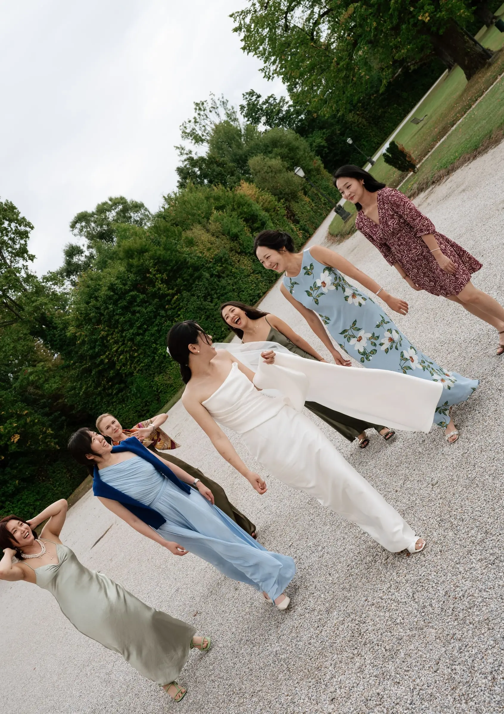 Bride dancing with her bridesmaids on the castle driveway