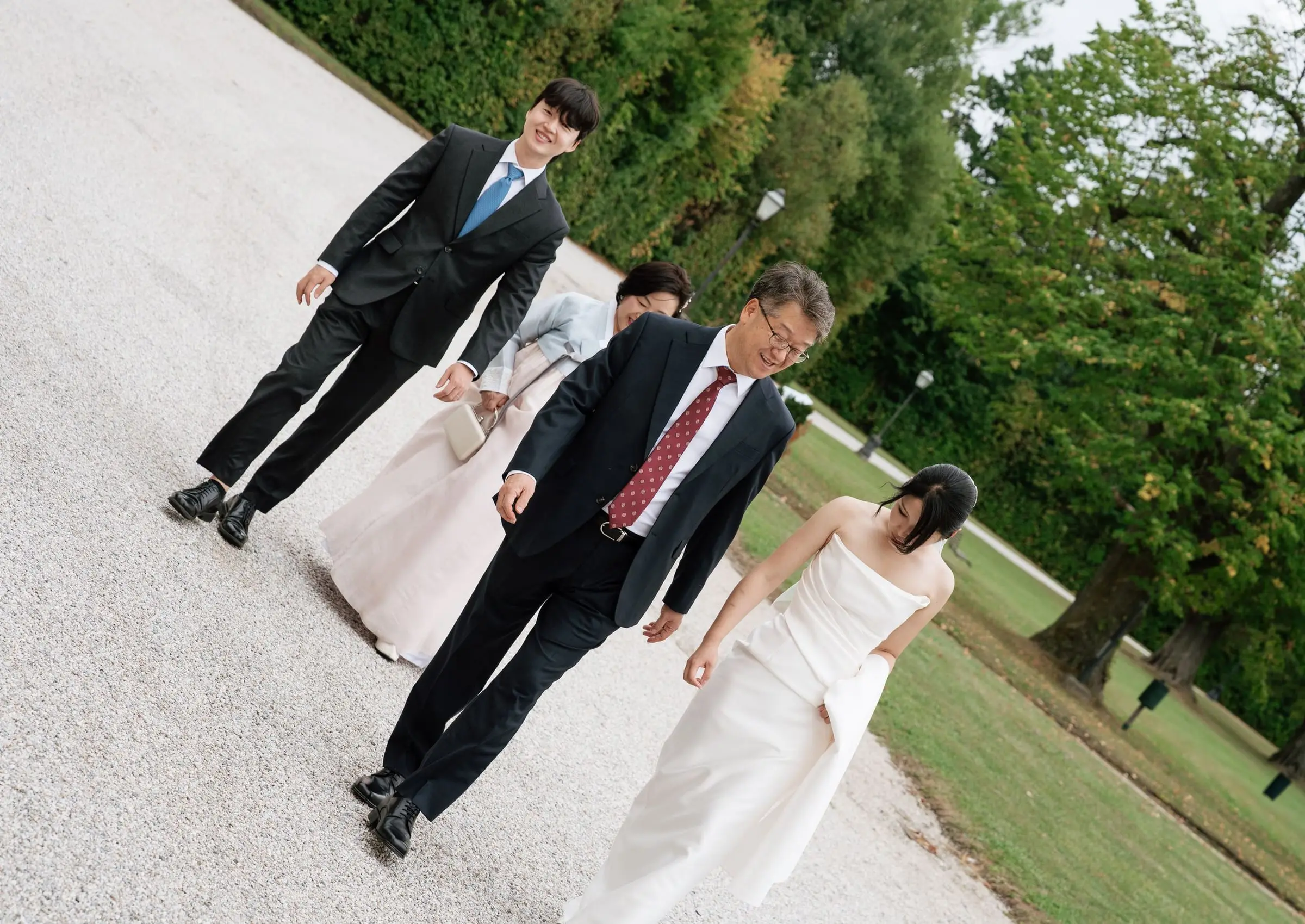 Bride walking with her father along the castle park path