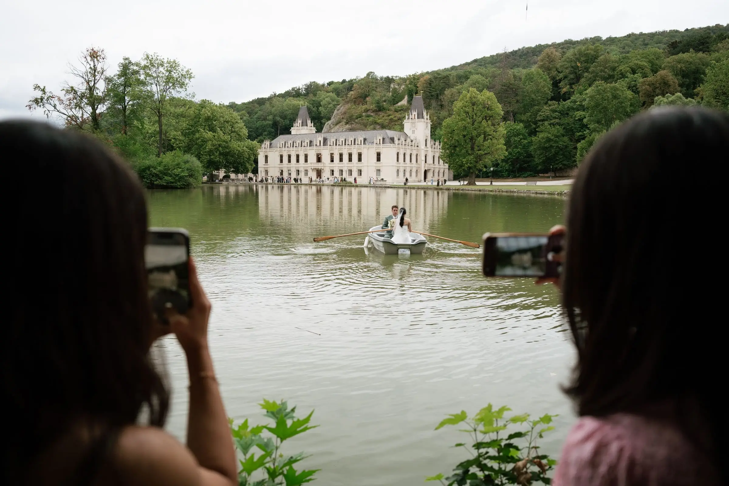 Guests filming the couple rowing on the castle lake at Schloss Hernstein