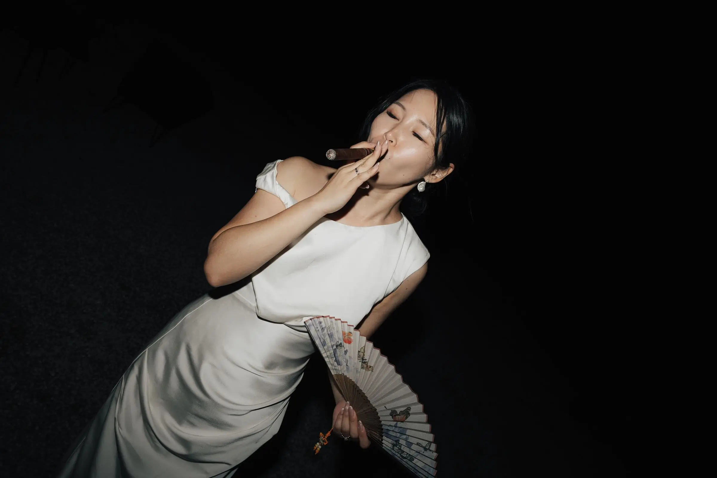 Bride blowing a kiss with a hand fan at the party
