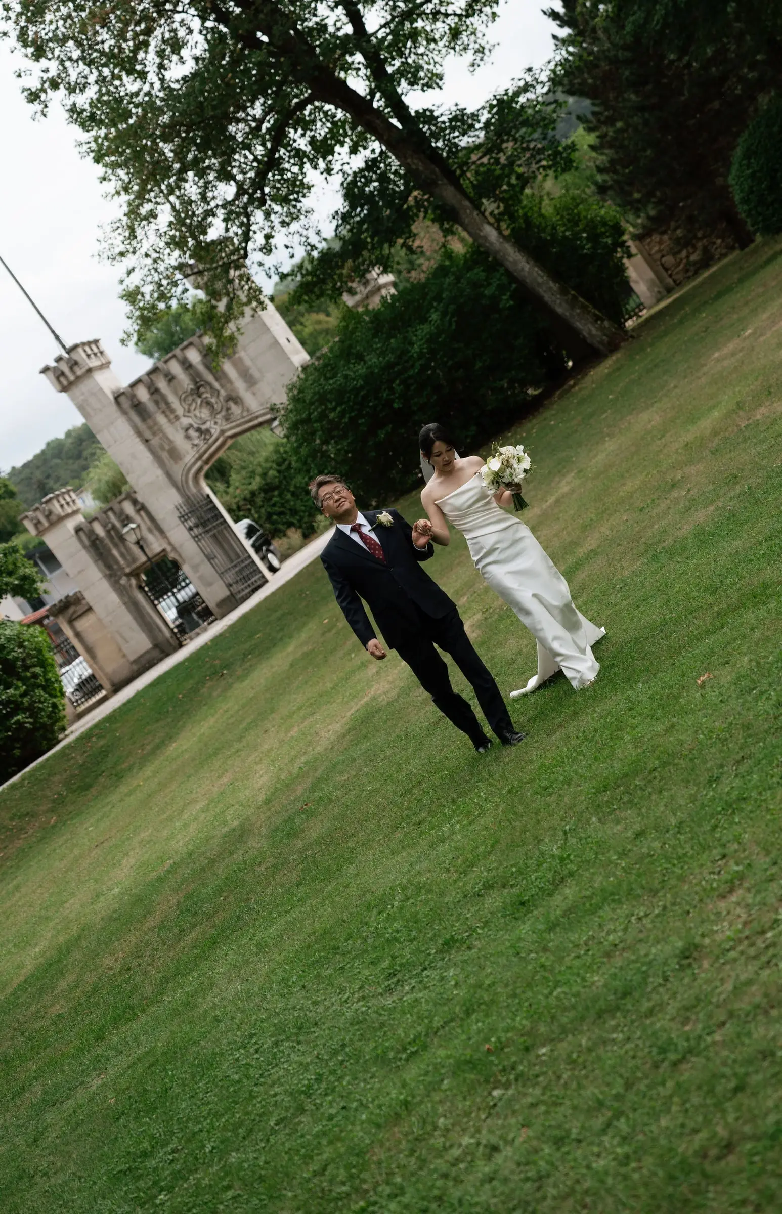 Newlyweds walking across the castle lawn
